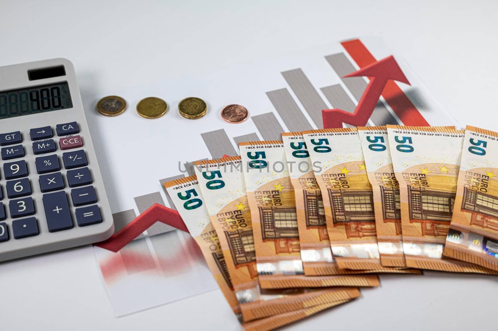 50 euro banknotes with graphs and calculator on white background