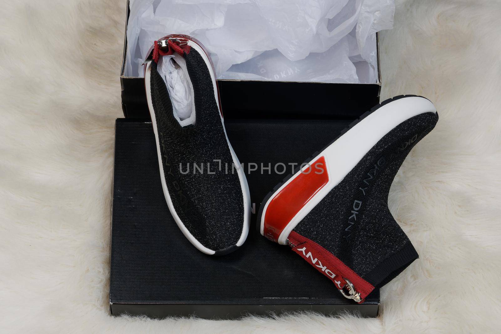 Display of delivered package containing a pair of DKNY fashion modern shoes with company logo.