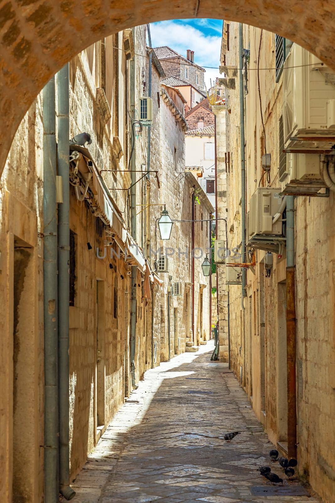 Dubrovnik, Croatia. Dubrovnik old street view with lanterns through the arch. Sunny morning.