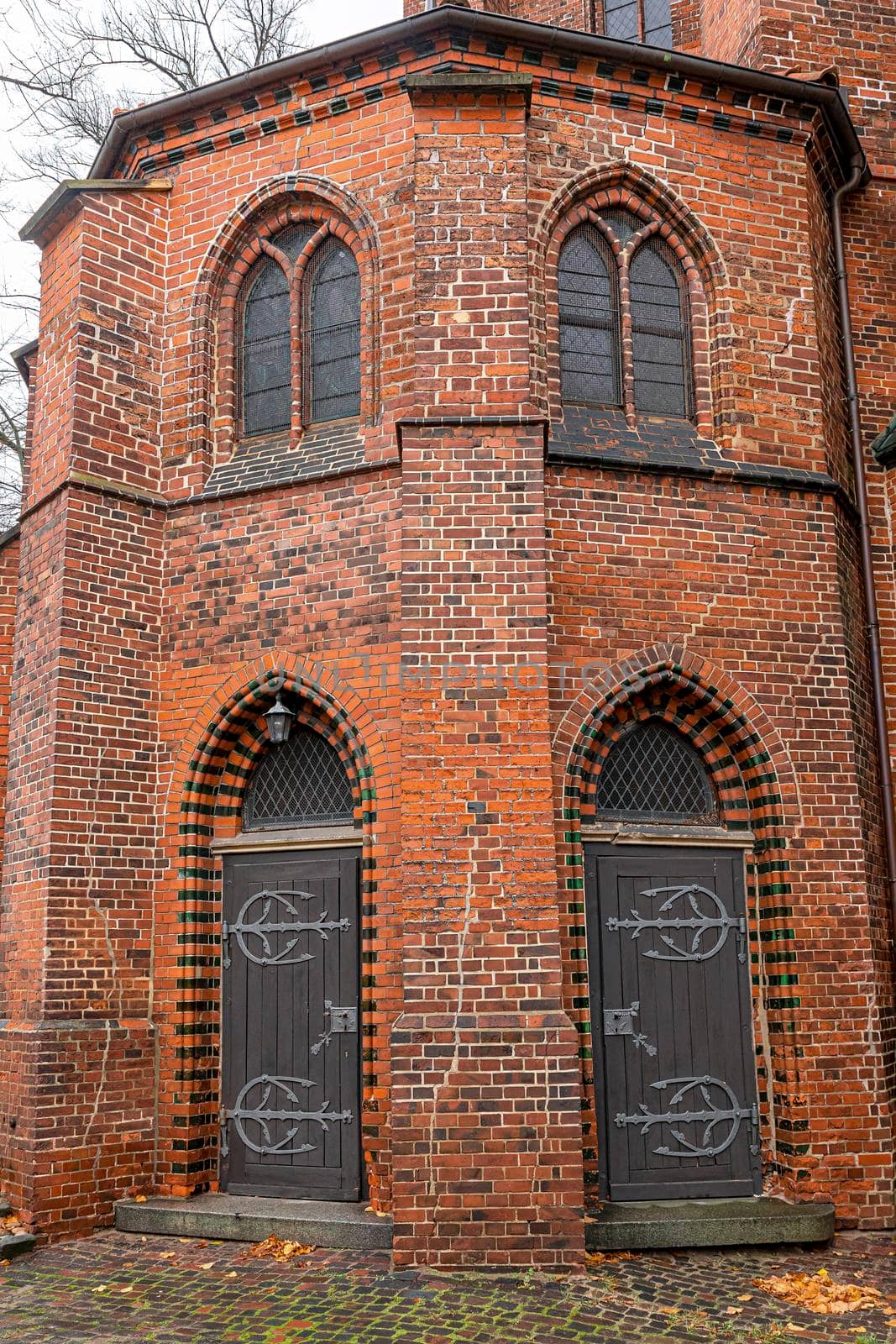 Fragment of a red brick building and the original doors of the Church of St. Michaelis in the old town of Lüneburg