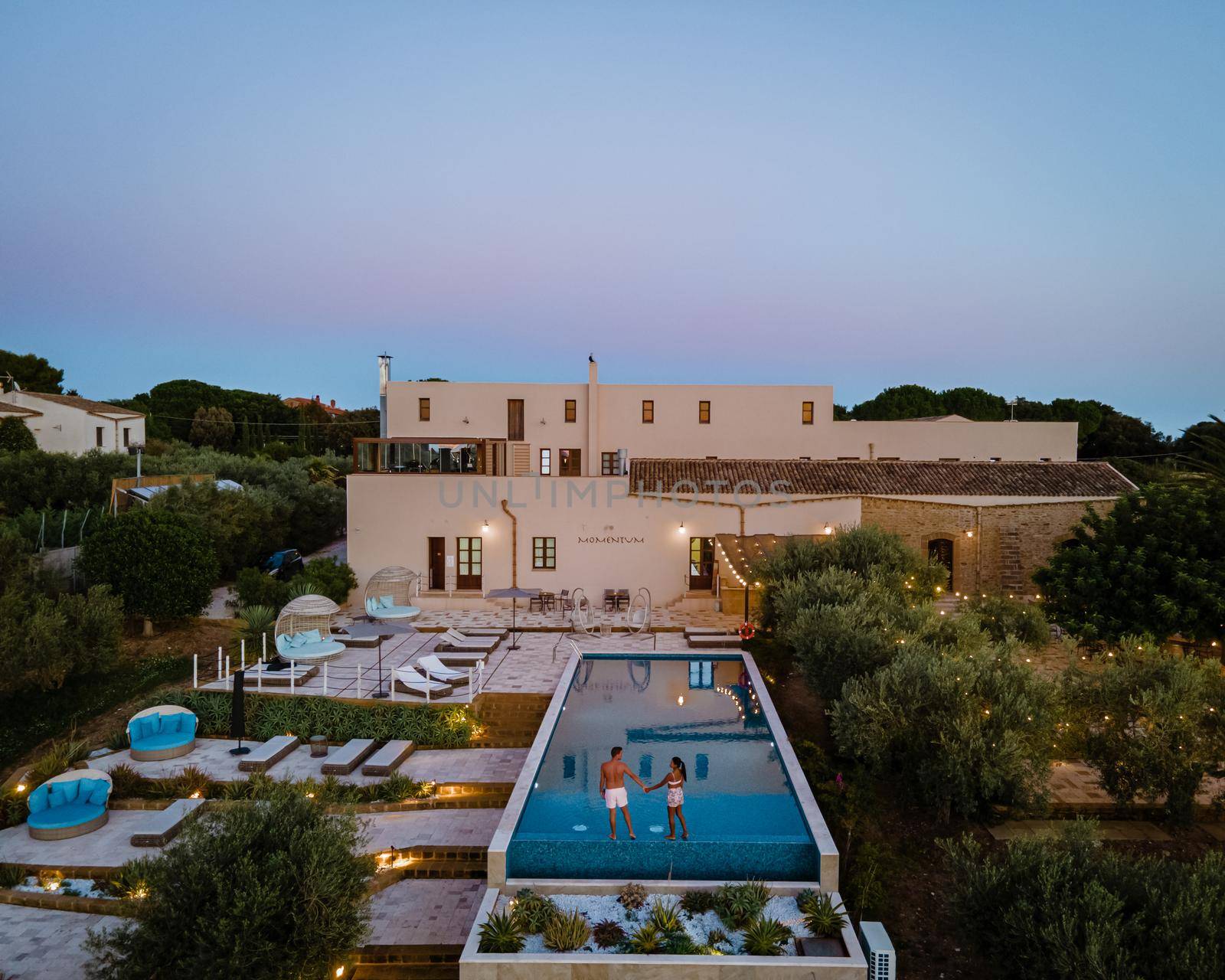 Luxury resort with a view over the wine field in Selinunte Sicily Italy. infinity pool with a view over wine fields in Sicilia, a couple on luxury vacation at the Island of Sicily Italy