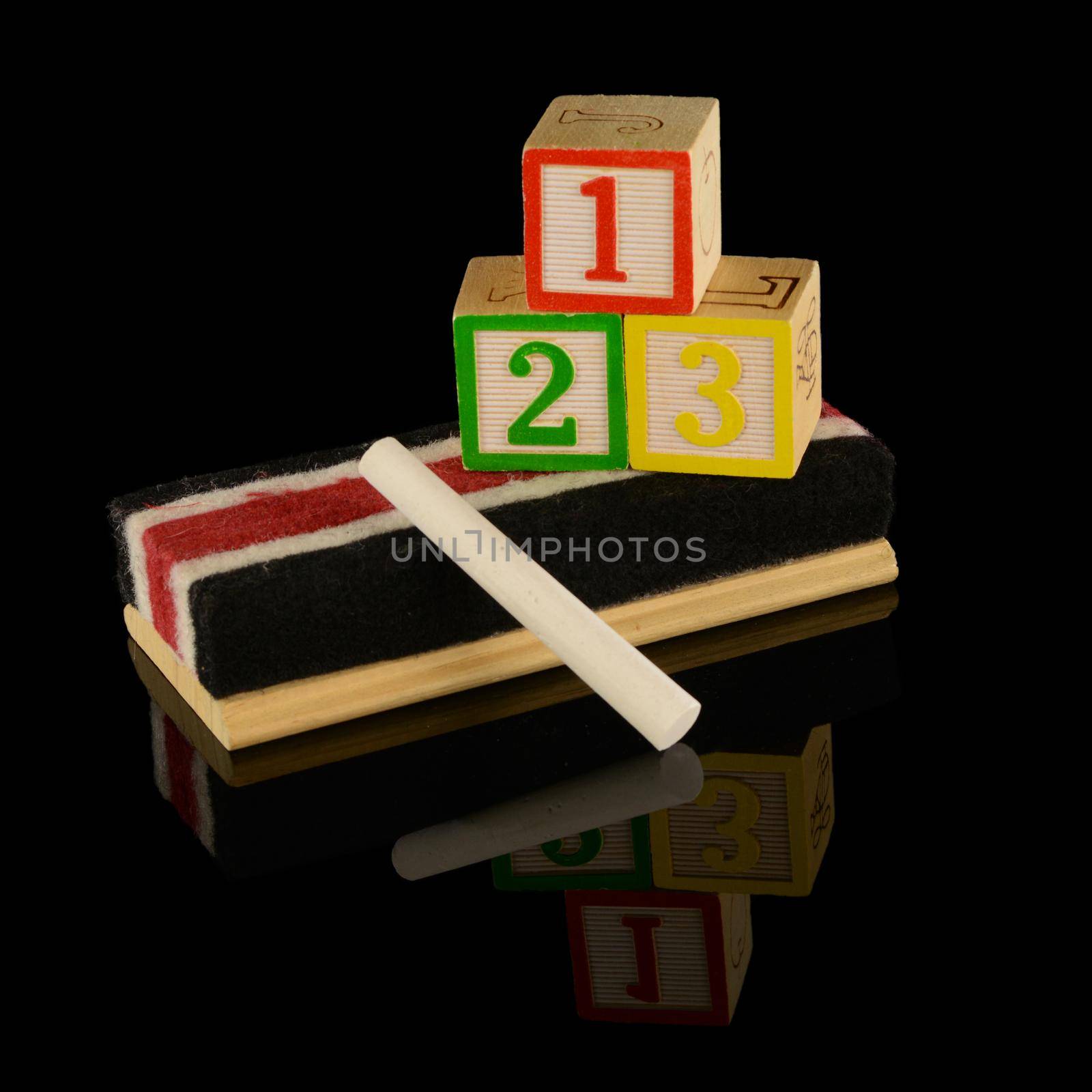 A grouping of preschool teacher items used for early childhood education over a black reflective background.