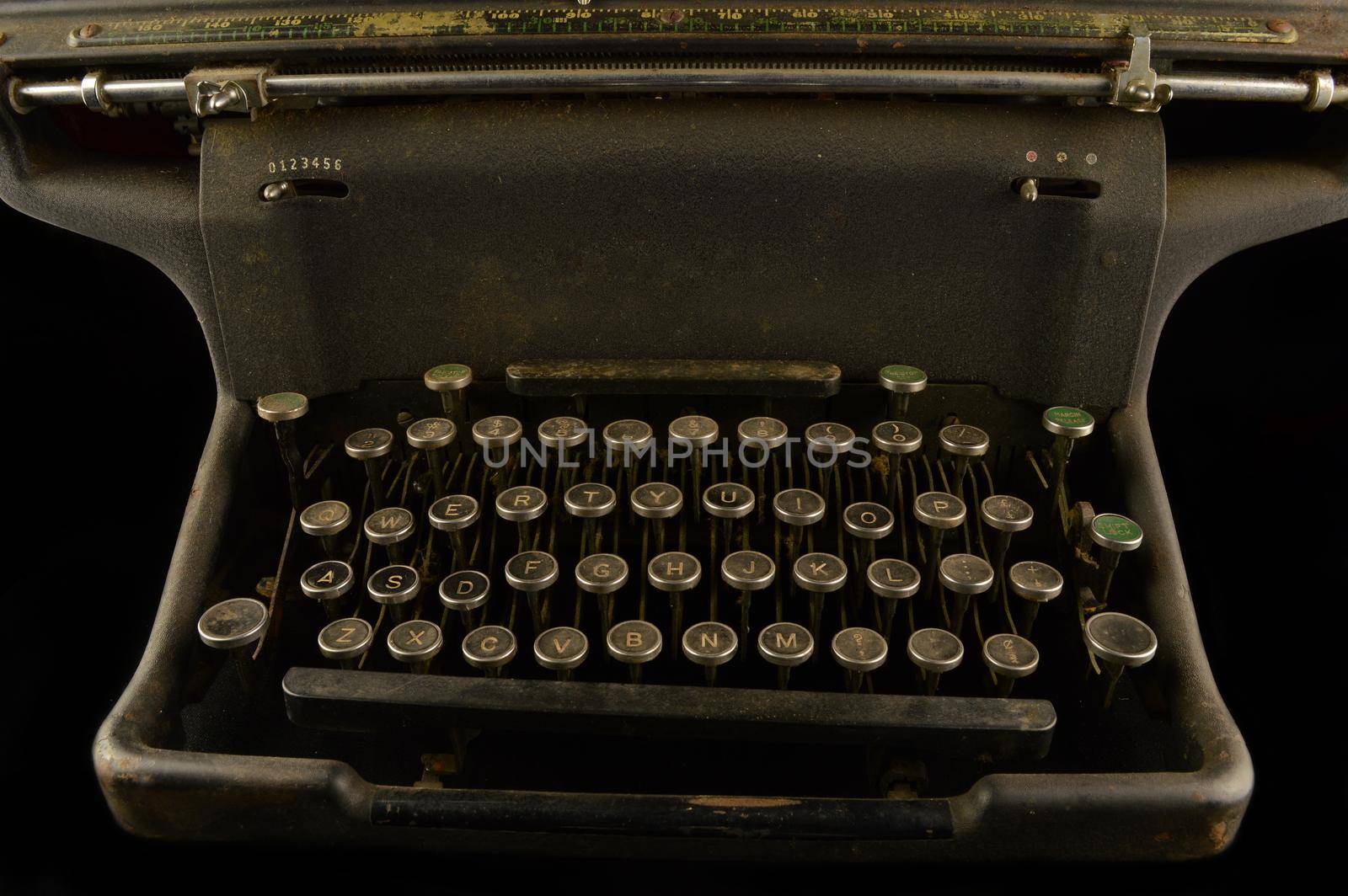 A closeup view of a vintage typewriter over a black background.