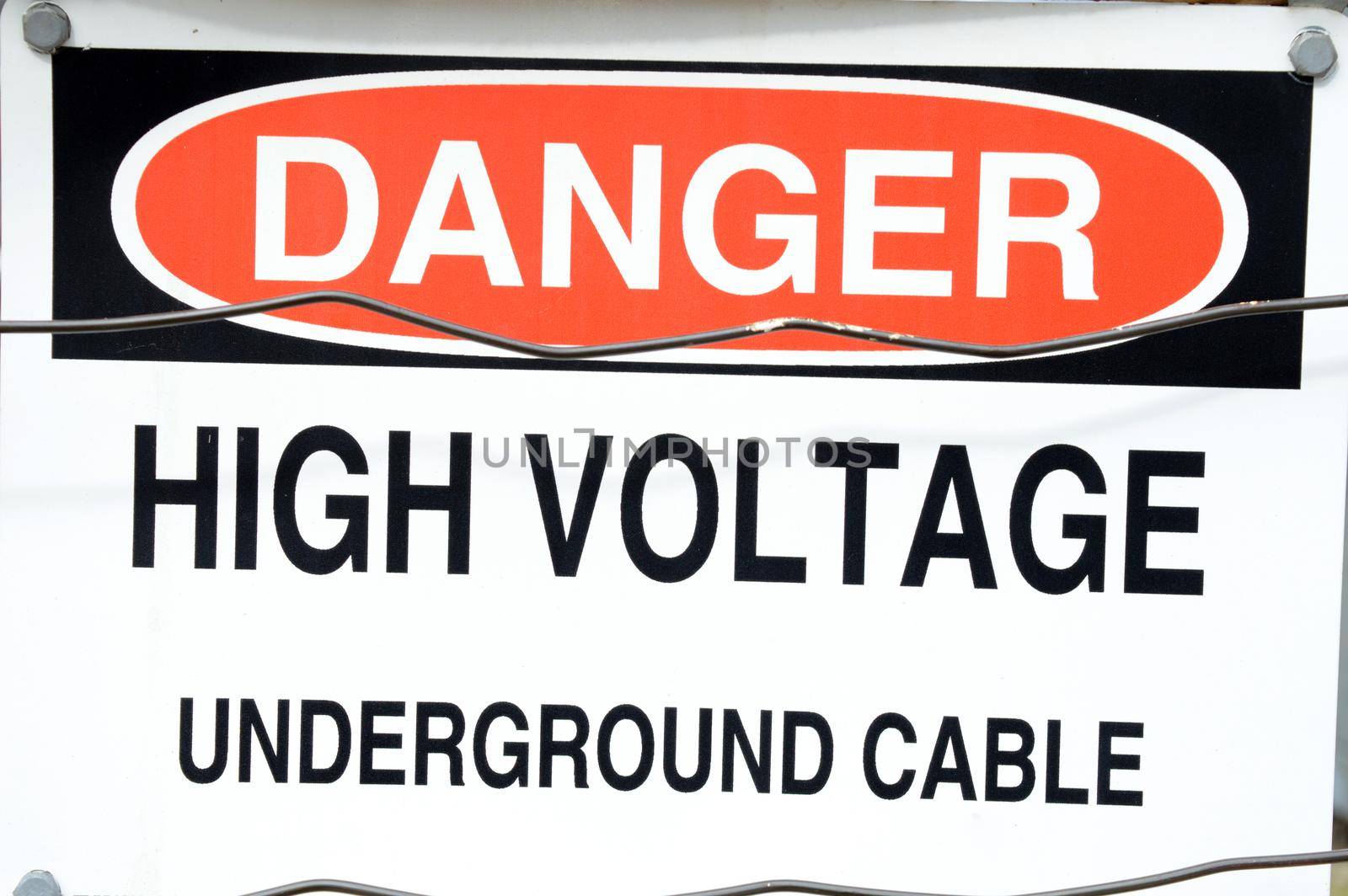 A closeup image of a high voltage warning signage claiming a dangerous zone.