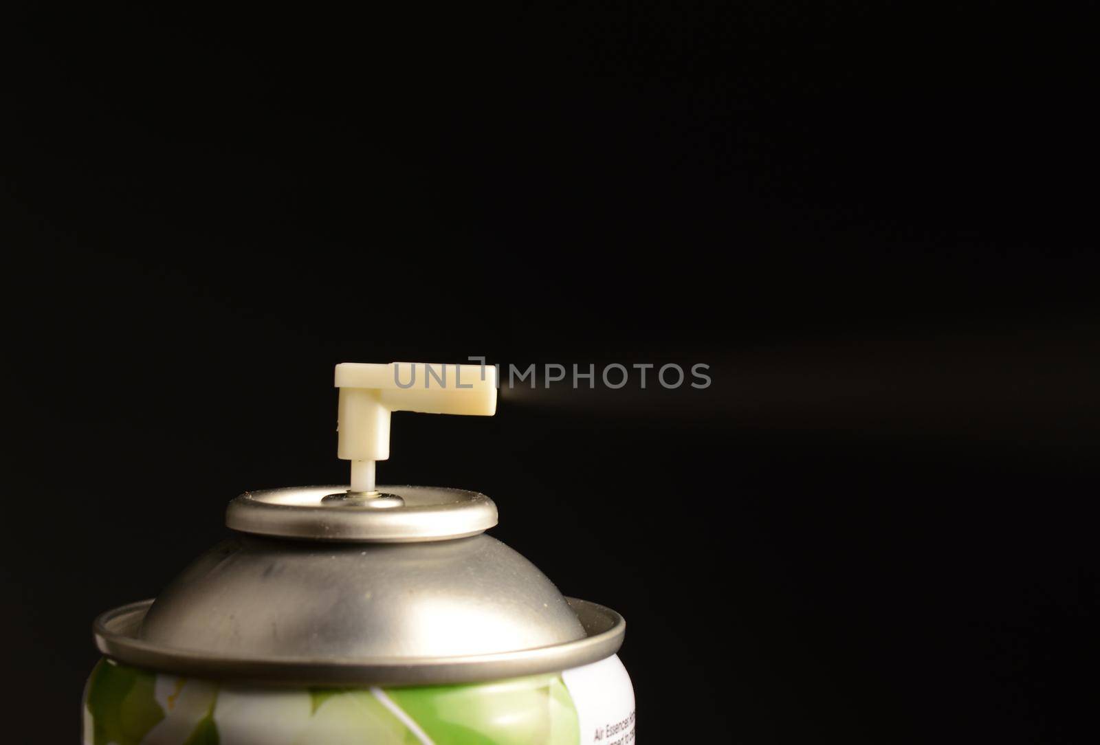 A closeup of a sanitation spray bottle over a black background.