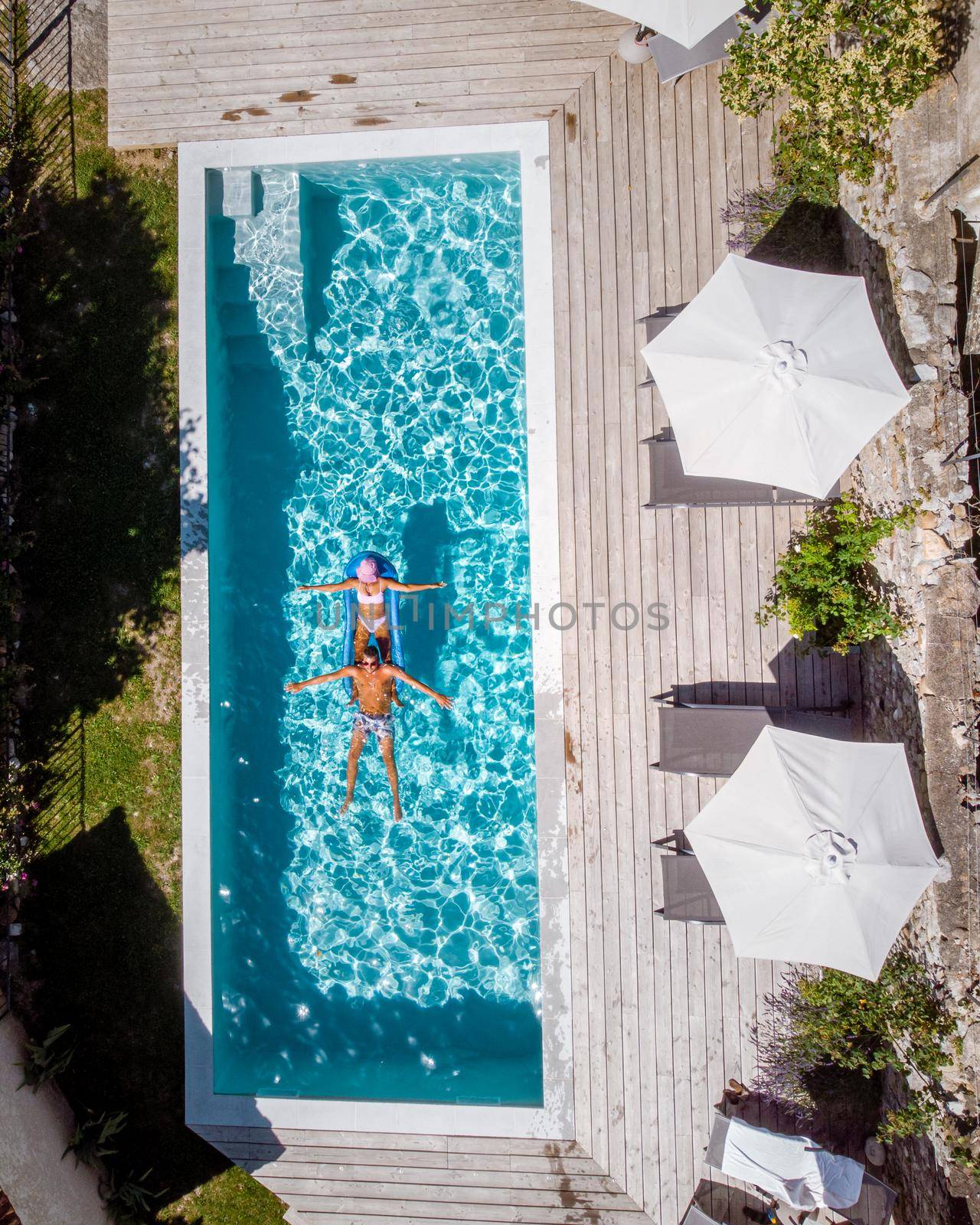 two person swim in the pool at the hotel. View from above, couple men and women in swimming pool of luxury vacation home in the Ardeche France by fokkebok