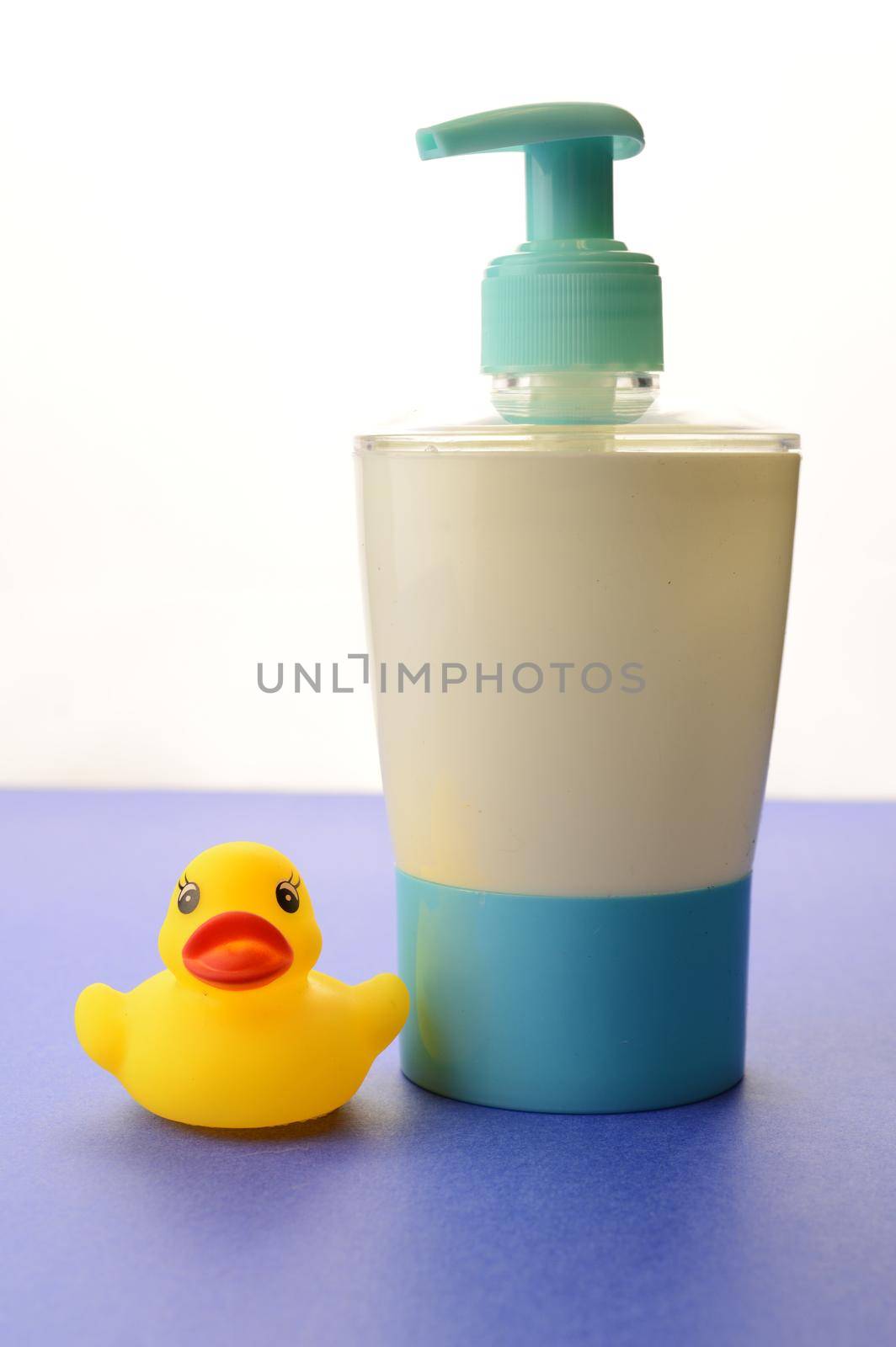 A liquid soap dispenser and rubber duck over a blue and white background remind us to wash our hands.