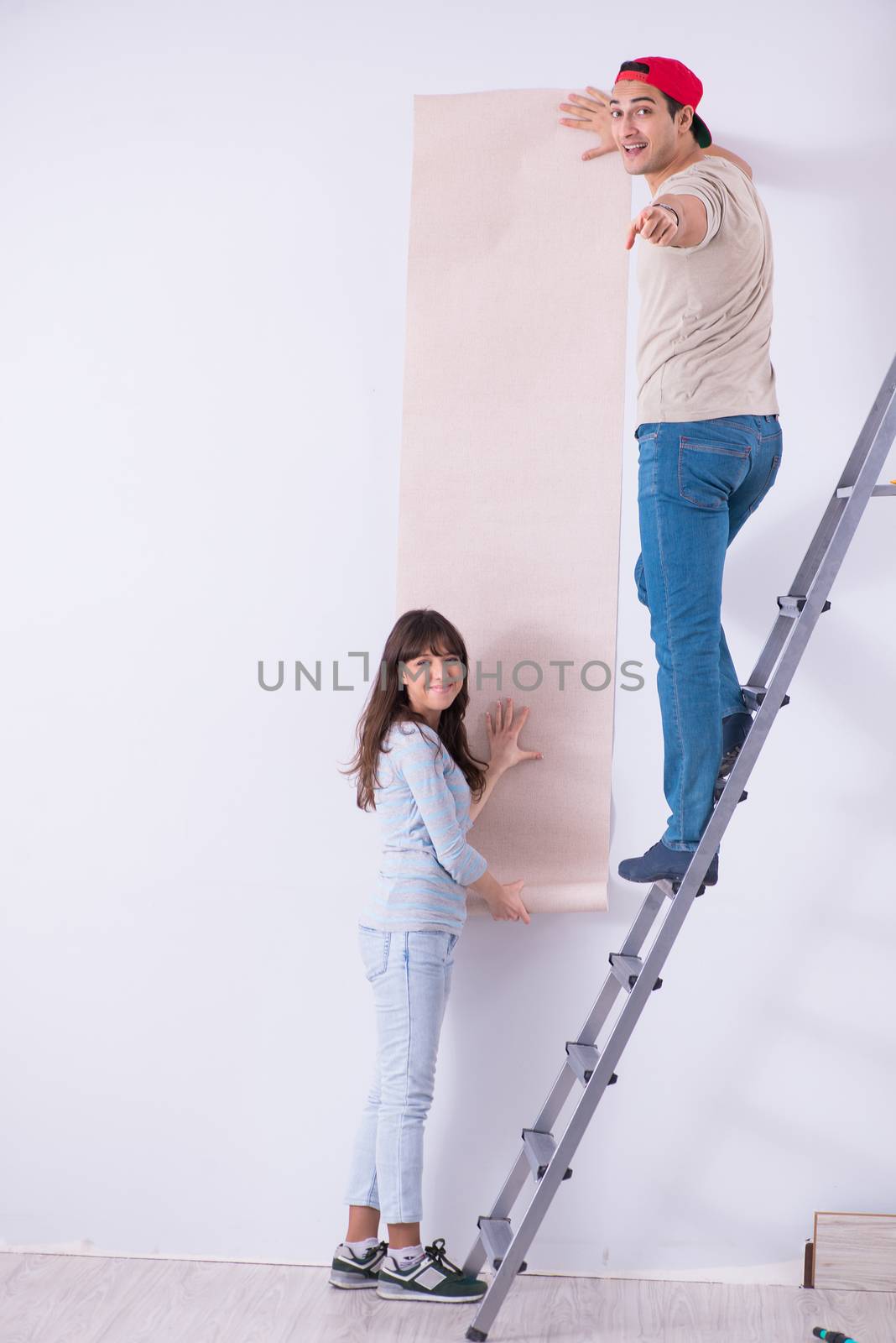 Young family doing renovation at home with new wallpaper by Elnur