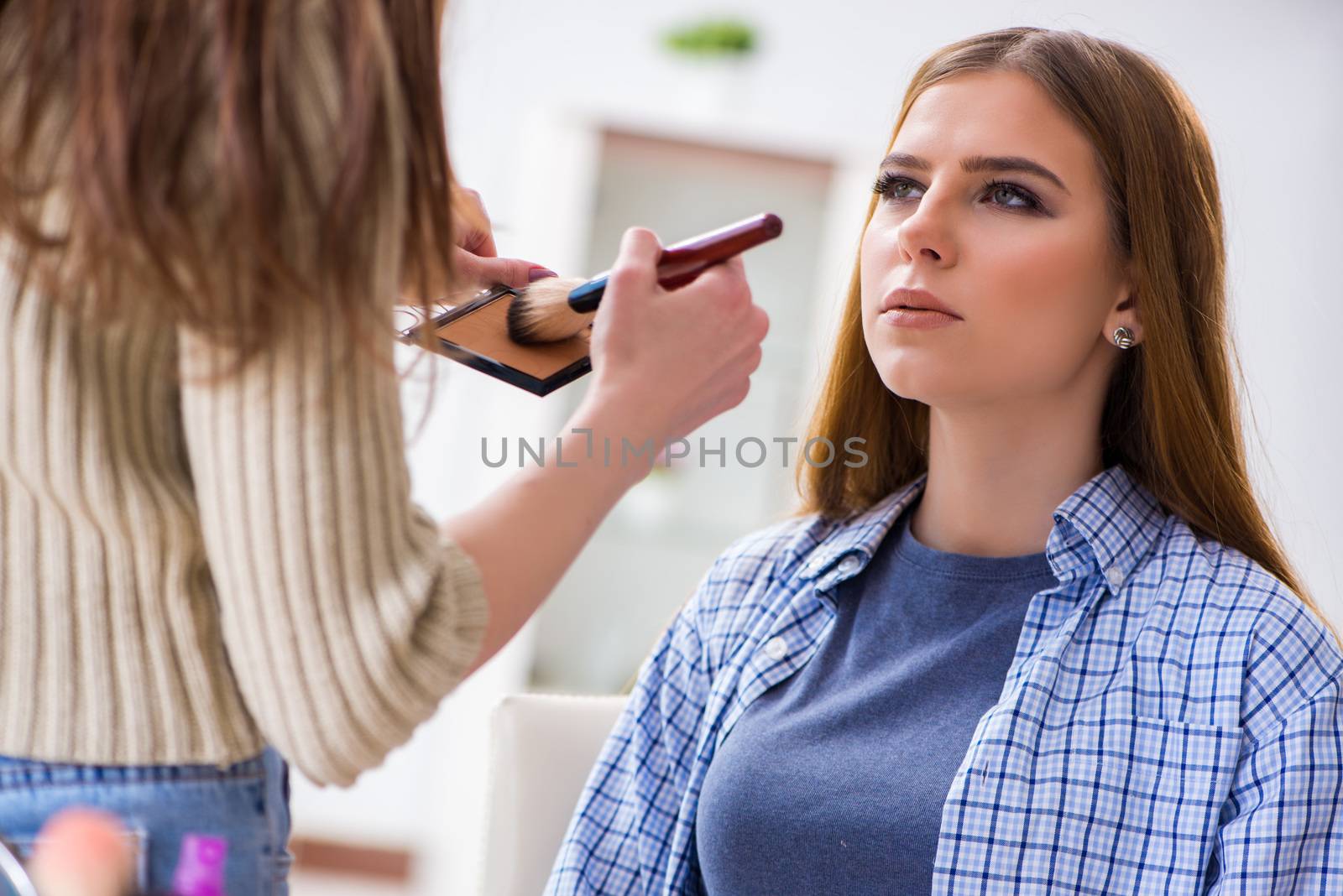 Woman getting her make-up done in beauty salon