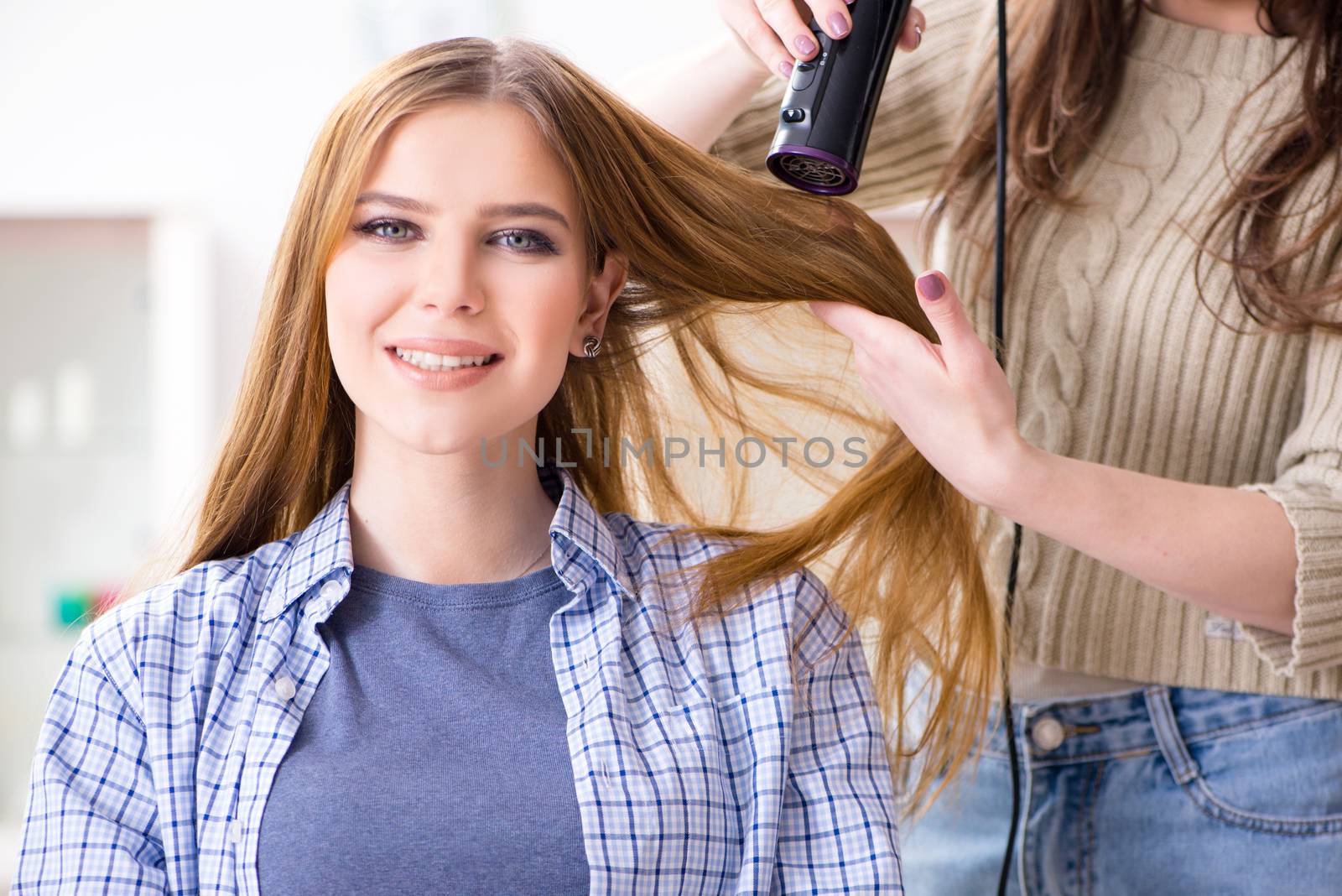 Woman getting her hair done in the beauty salon by Elnur
