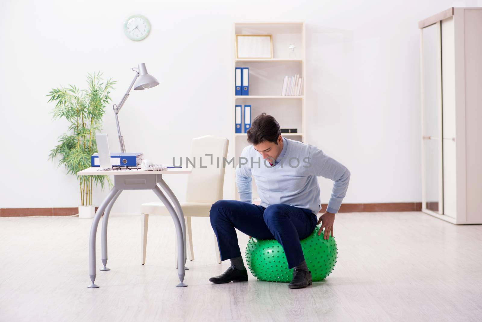 Employee exercising with swiss ball during lunch break