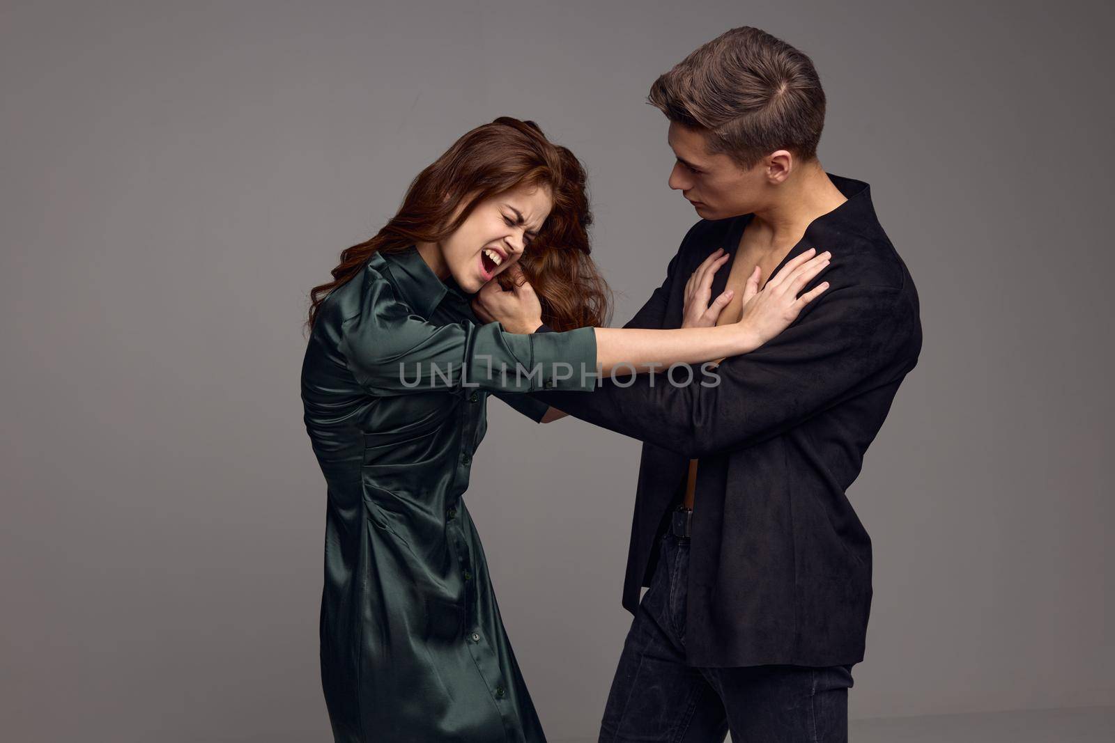 Aggressive woman and strict man on a gray background of conflict misunderstanding. High quality photo