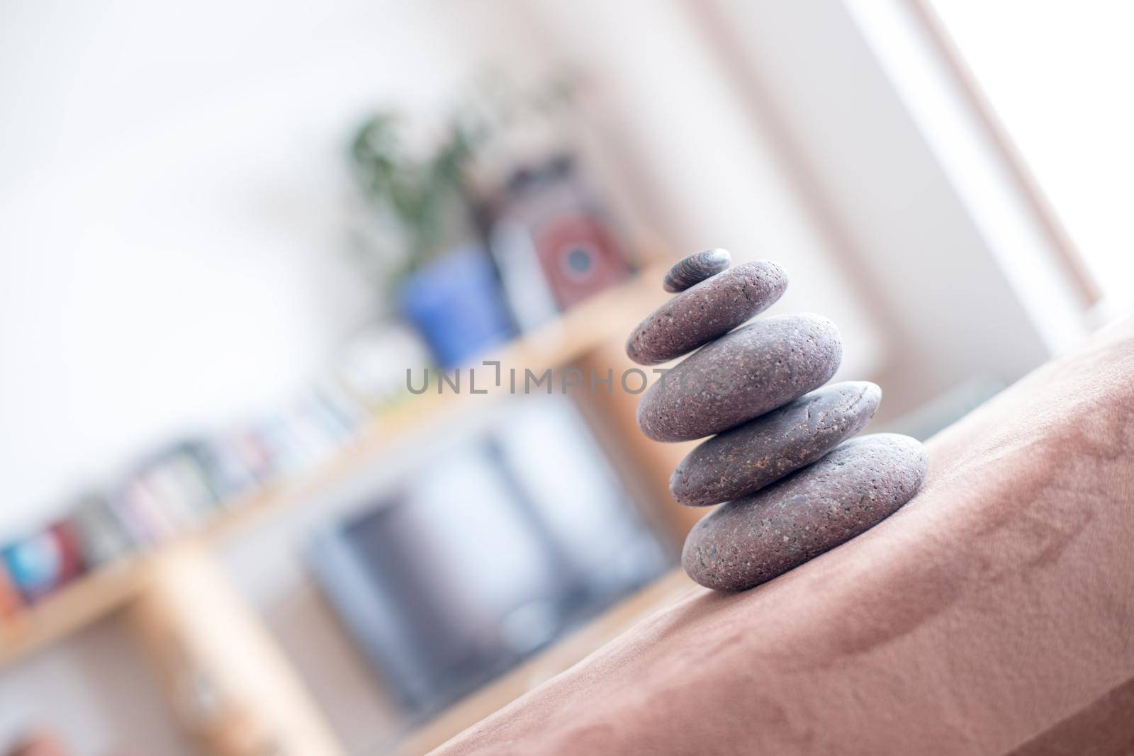 Feng Shui: Stone cairn in the foreground, blurry living room in the background. Balance and relaxation.