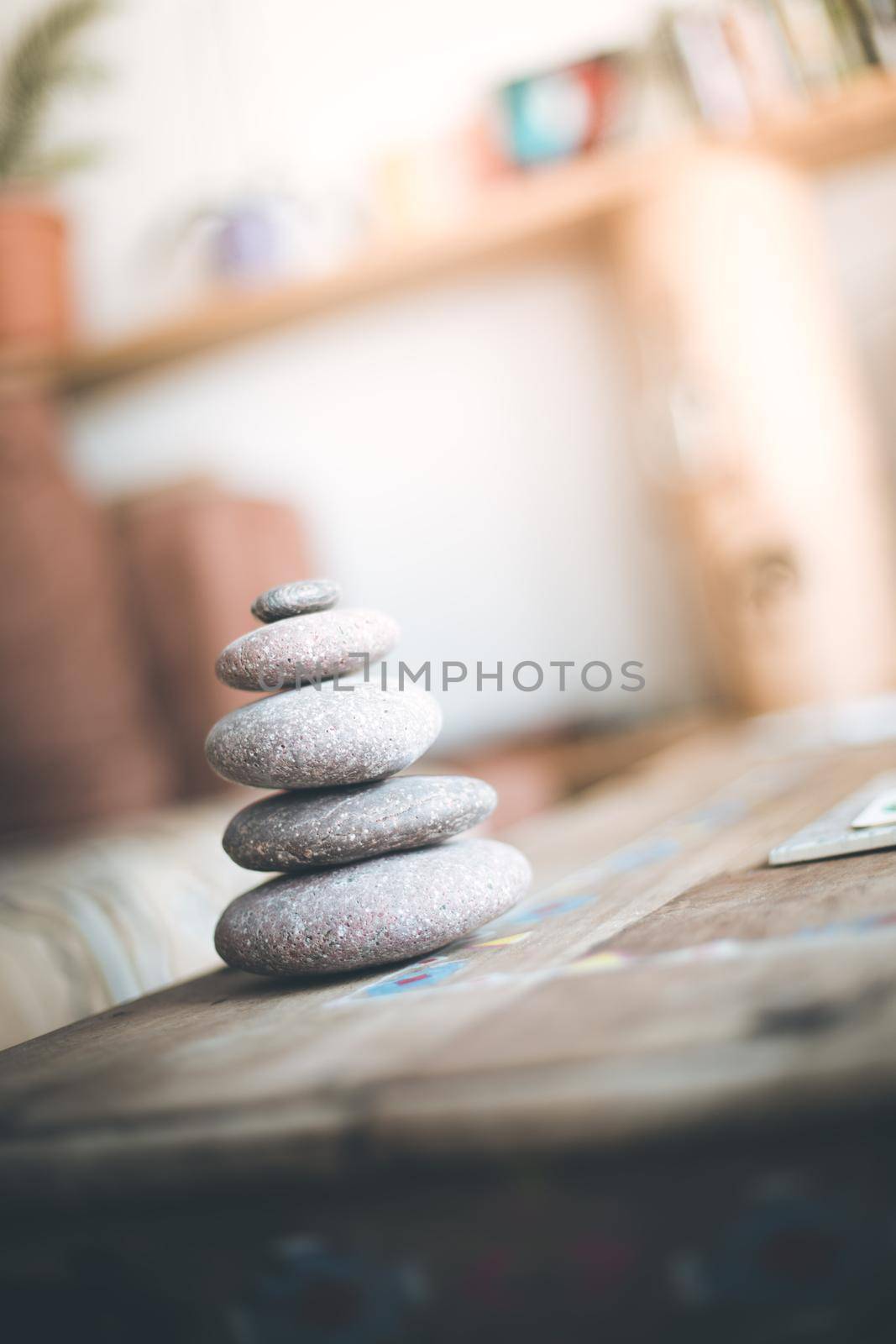 Feng Shui: Stone cairn in the foreground, blurry living room in the background. Balance and relaxation.