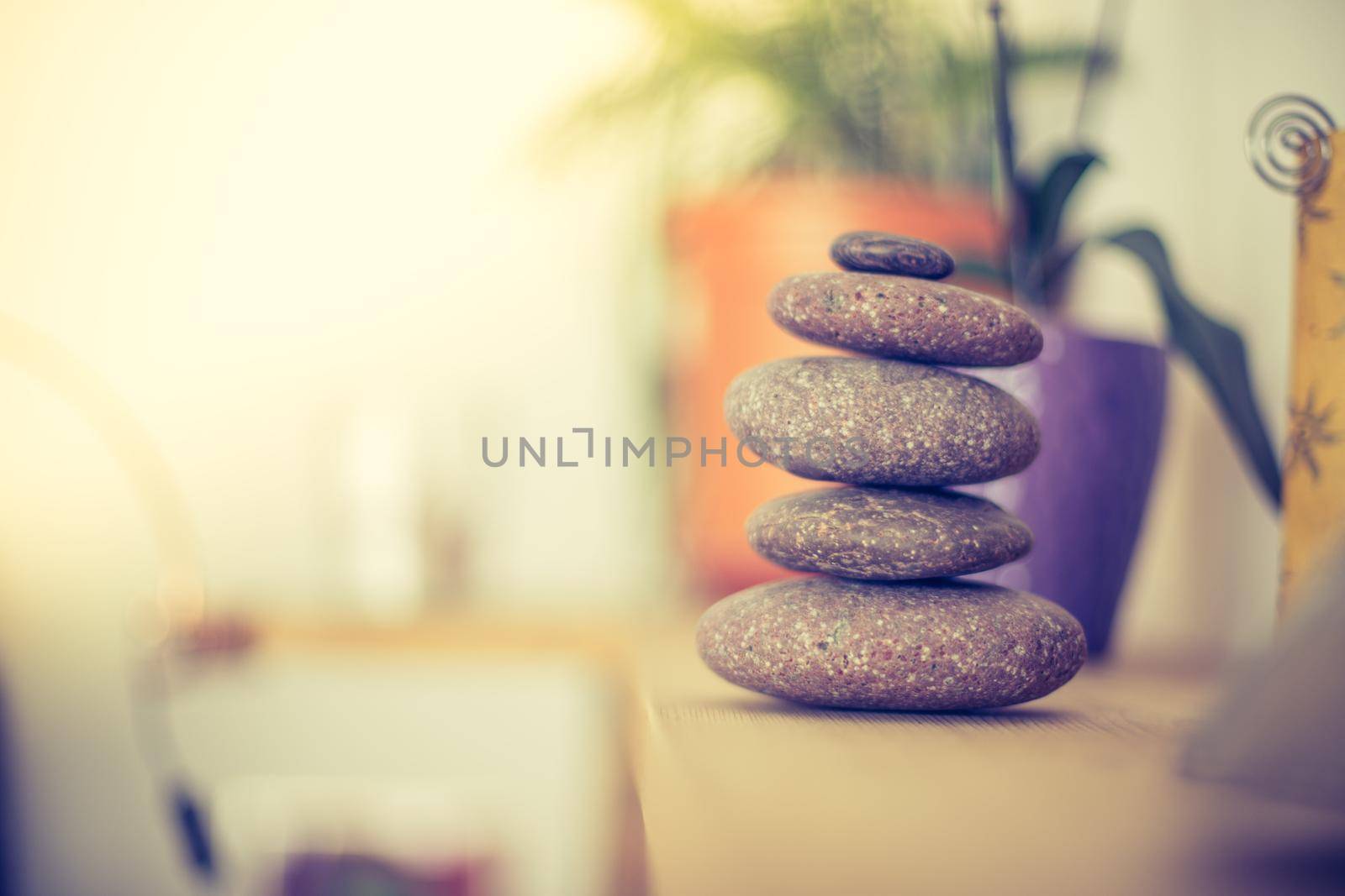 Feng Shui: Stone cairn in the foreground, blurry living room in the background. Balance and relaxation.
