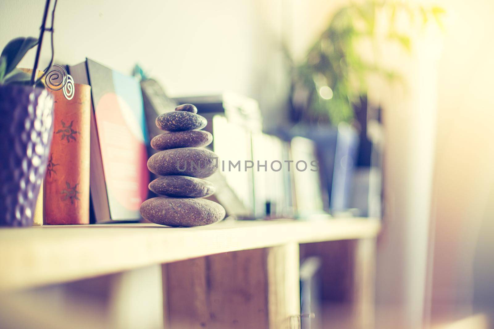 Feng Shui: Stone cairn in the foreground, blurry living room in the background. Balance and relaxation.