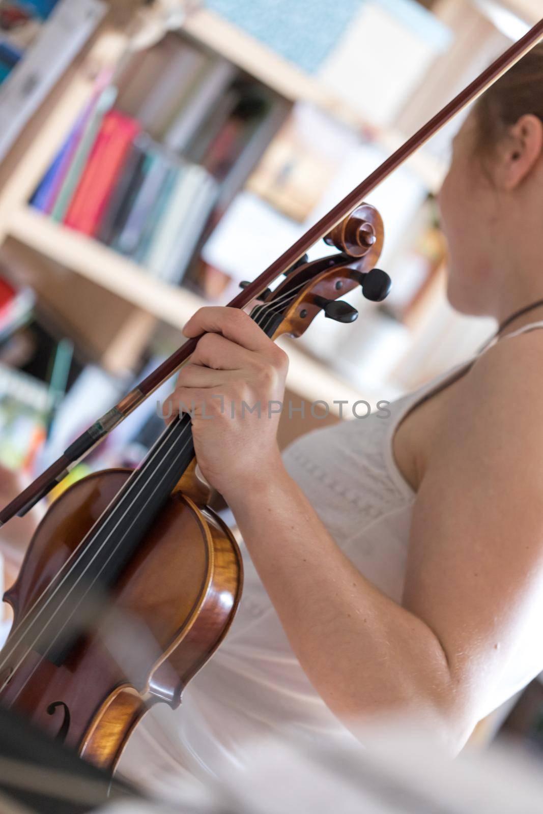 Young girl happily plays on her violin by Daxenbichler