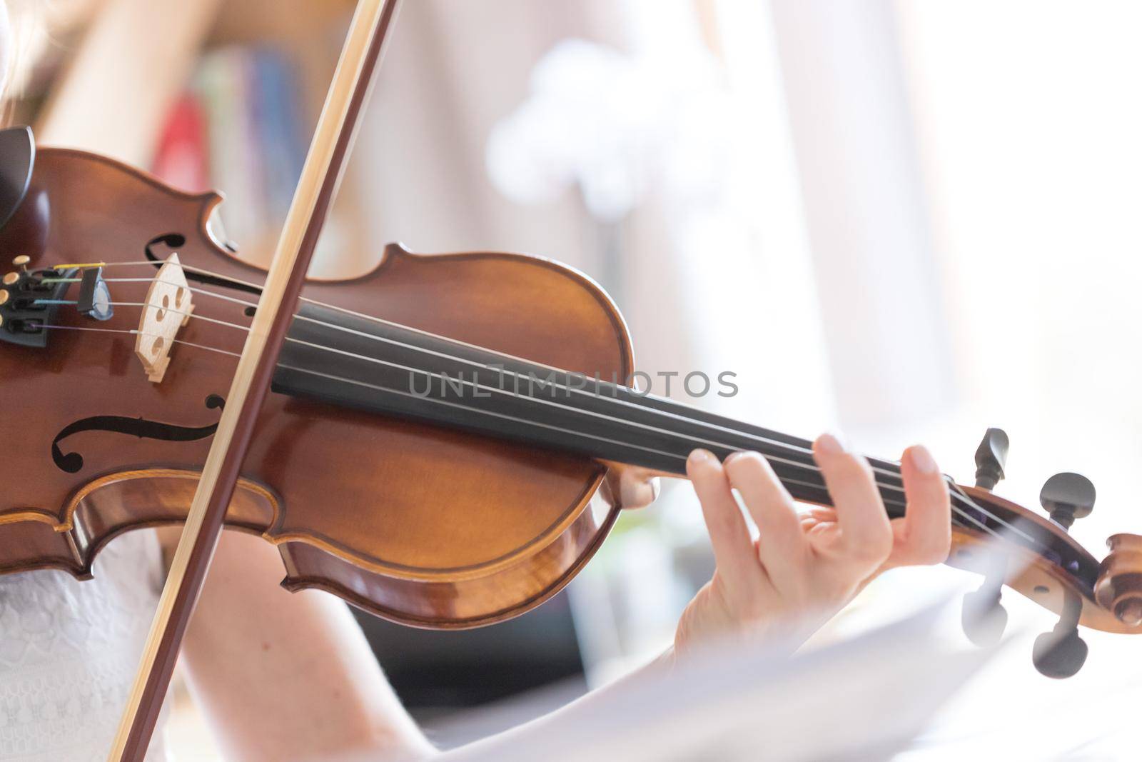 Pretty young girl practices on her violin, acoustic music