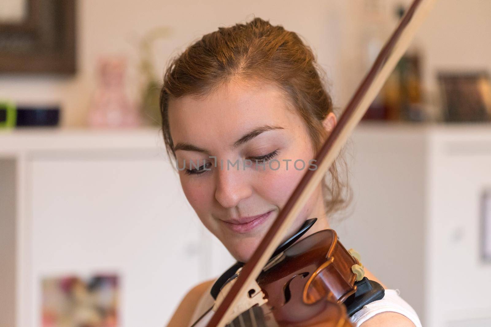 Pretty young girl practices on her violin, acoustic music