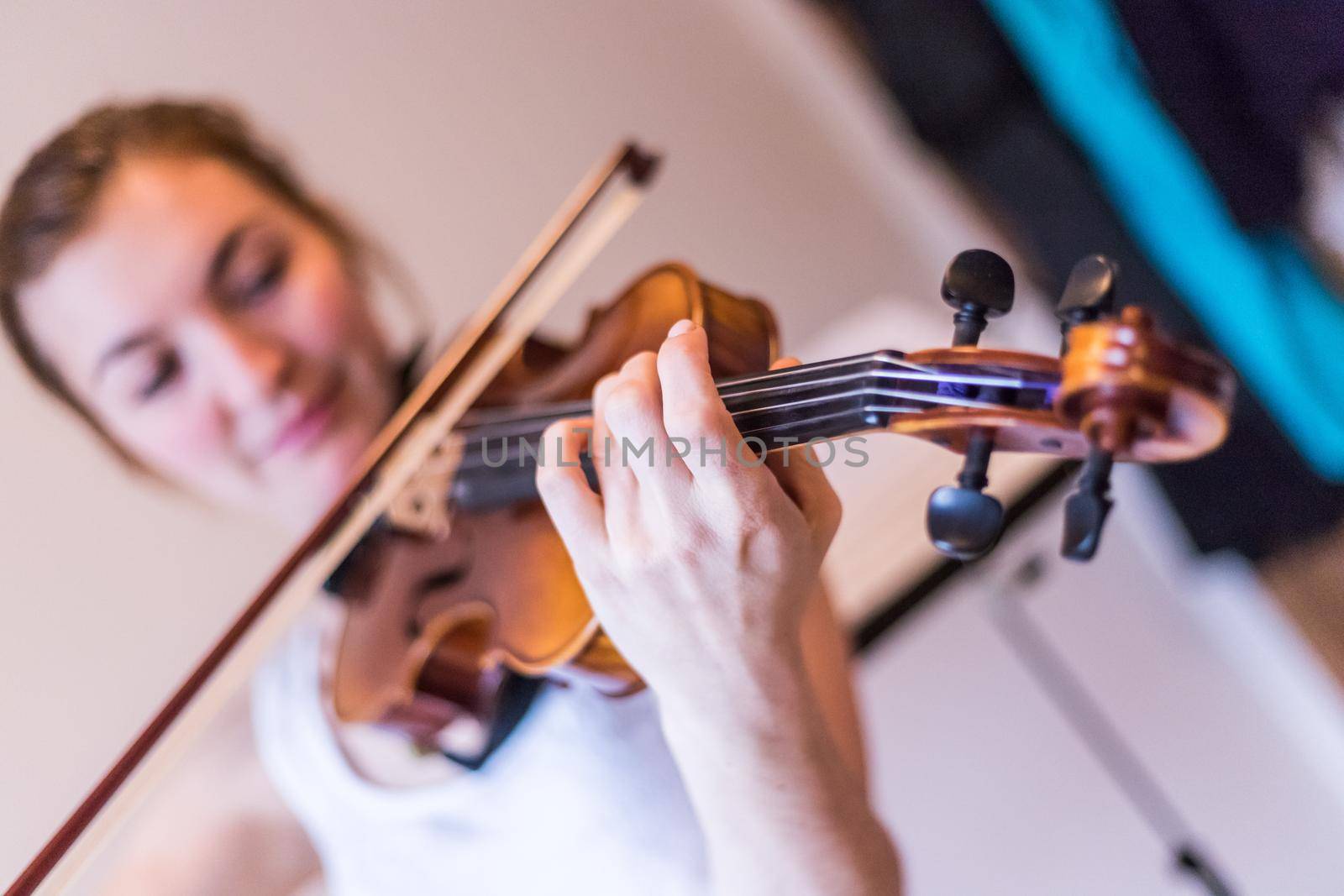 Young girl happily plays on her violin by Daxenbichler