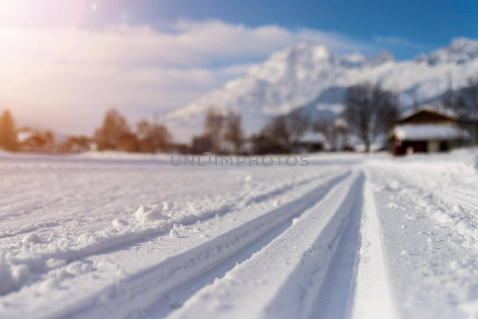 Cross-country skiing in Austria: Slope, fresh white powder snow and mountains, blurry background by Daxenbichler
