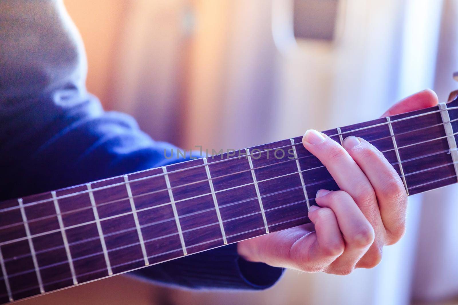 Musician plays a classical guitar, hands, fretboard and fingers