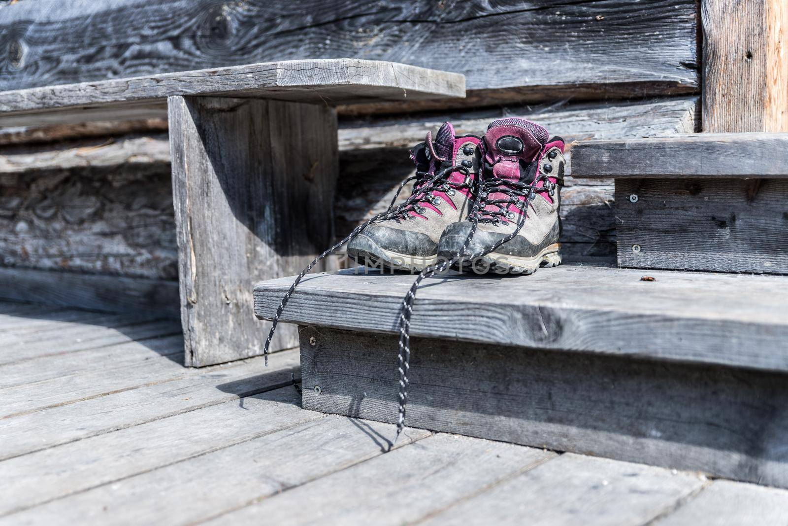 Close up picture of hiking boots on a rustic wooden veranda of an alpine hut