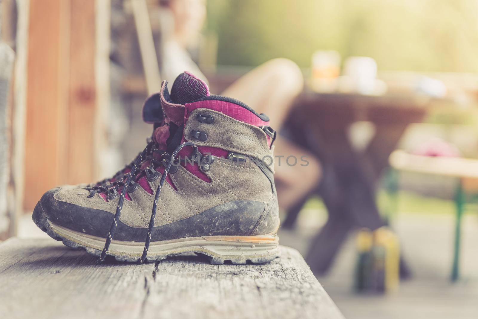 Close up picture of hiking boots on a rustic wooden veranda of an alpine hut