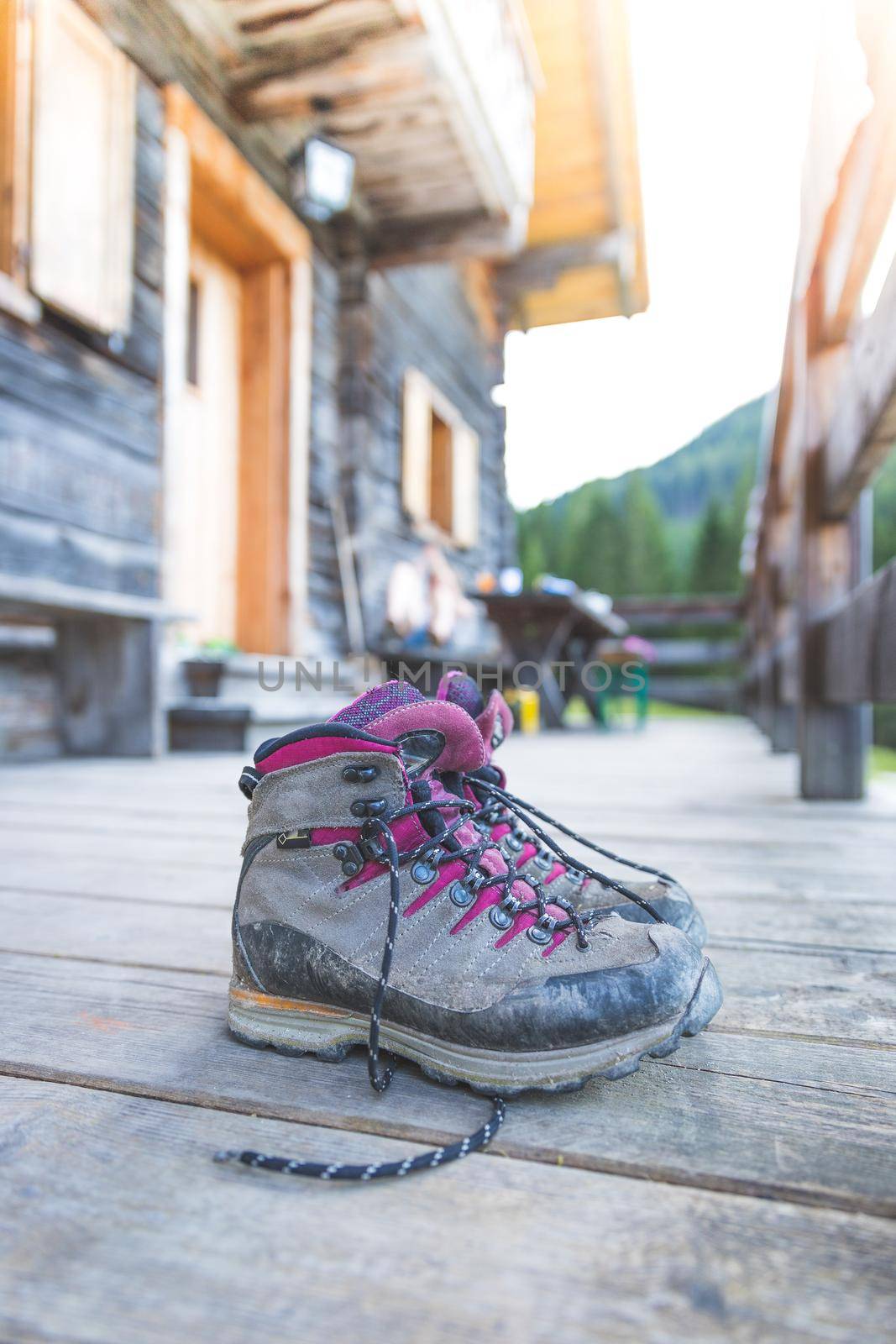 Close up picture of hiking boots on a rustic wooden veranda of an alpine hut