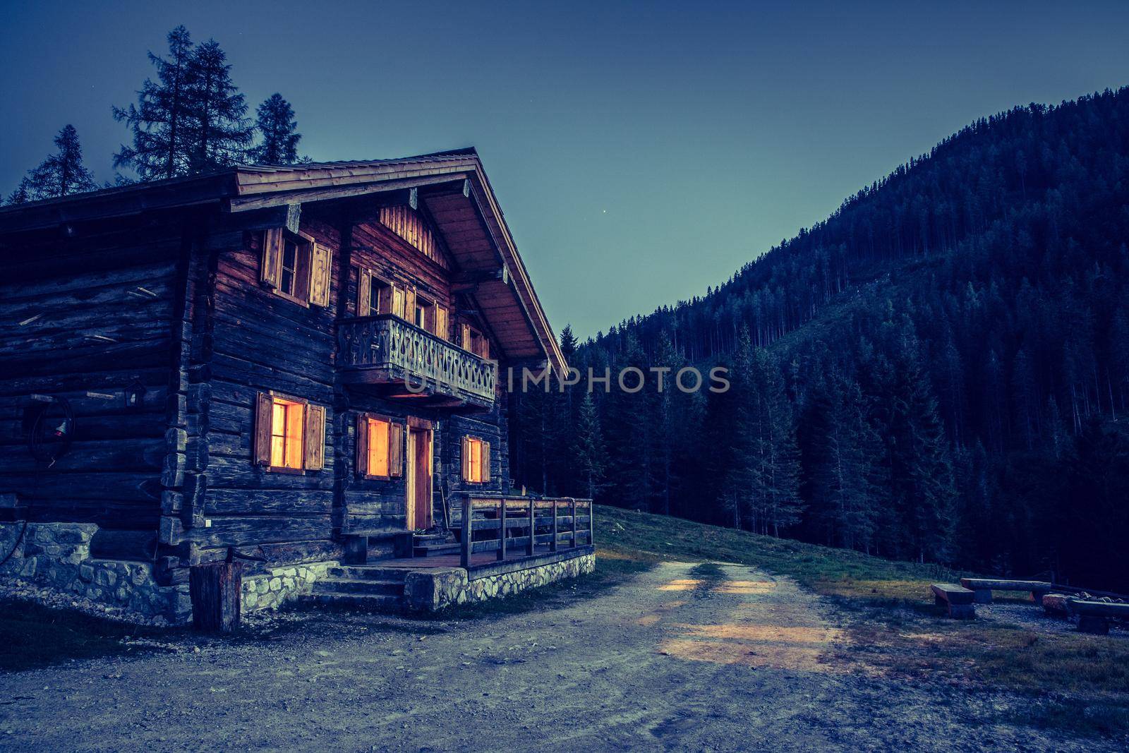 Holiday in the alps: Rustic wooden farm hut in the night. by Daxenbichler