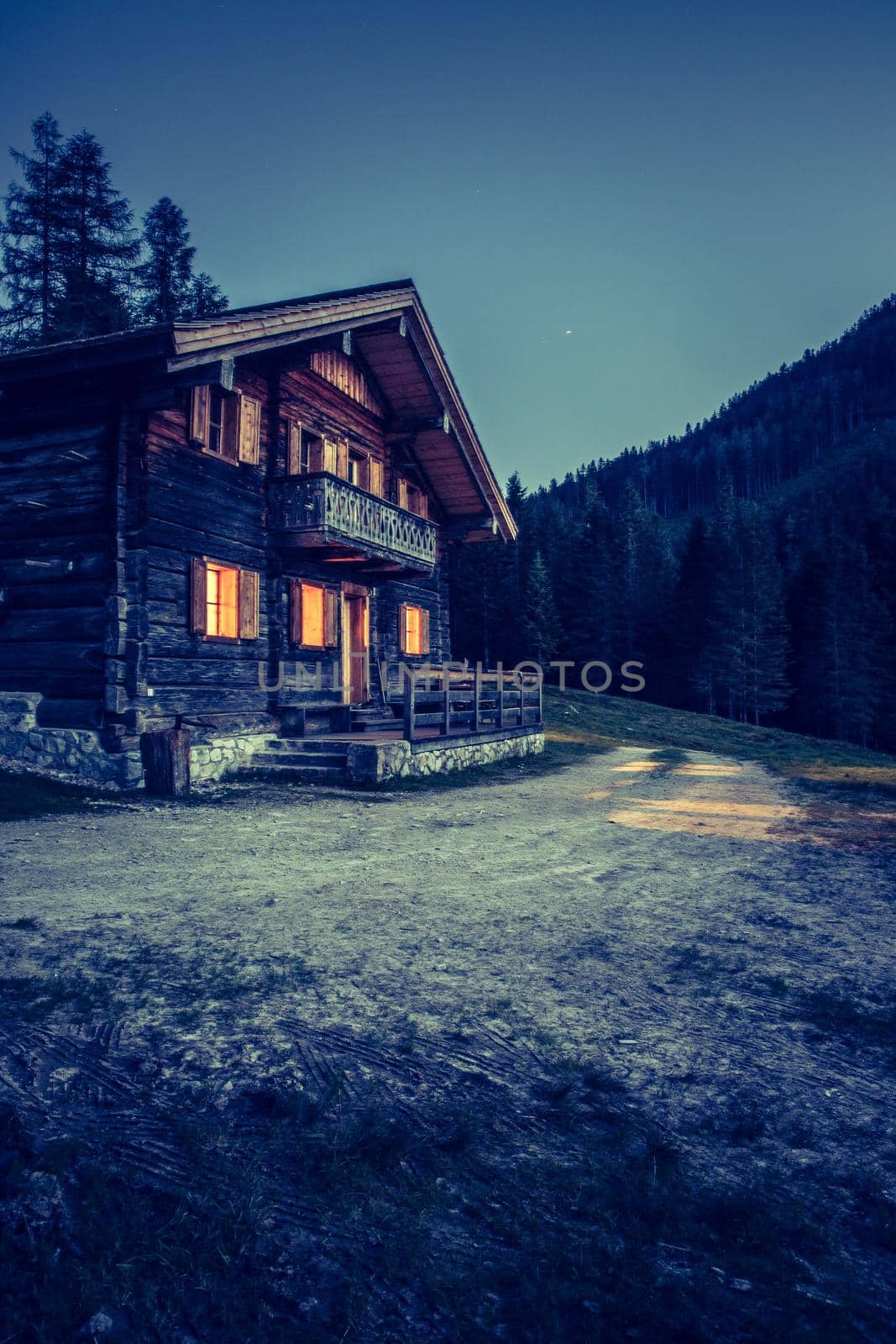 Holiday in the alps: Rustic wooden farm hut in the night. by Daxenbichler