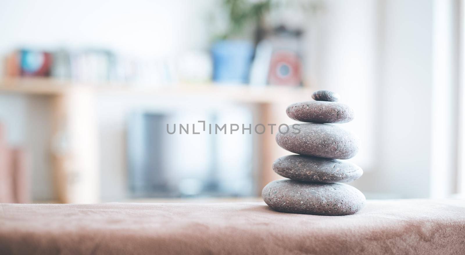 Feng Shui: Stone cairn in the foreground, blurry living room in the background. Balance and relaxation.