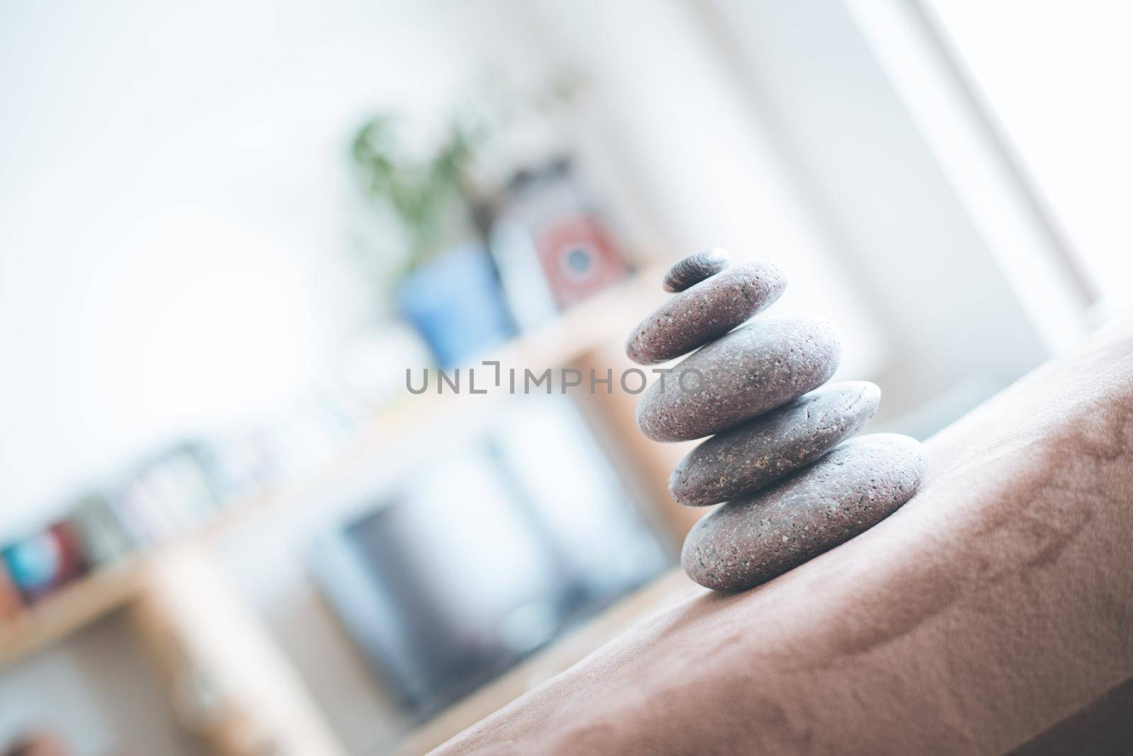 Feng Shui: Stone cairn in the foreground, blurry living room in the background. Balance and relaxation.