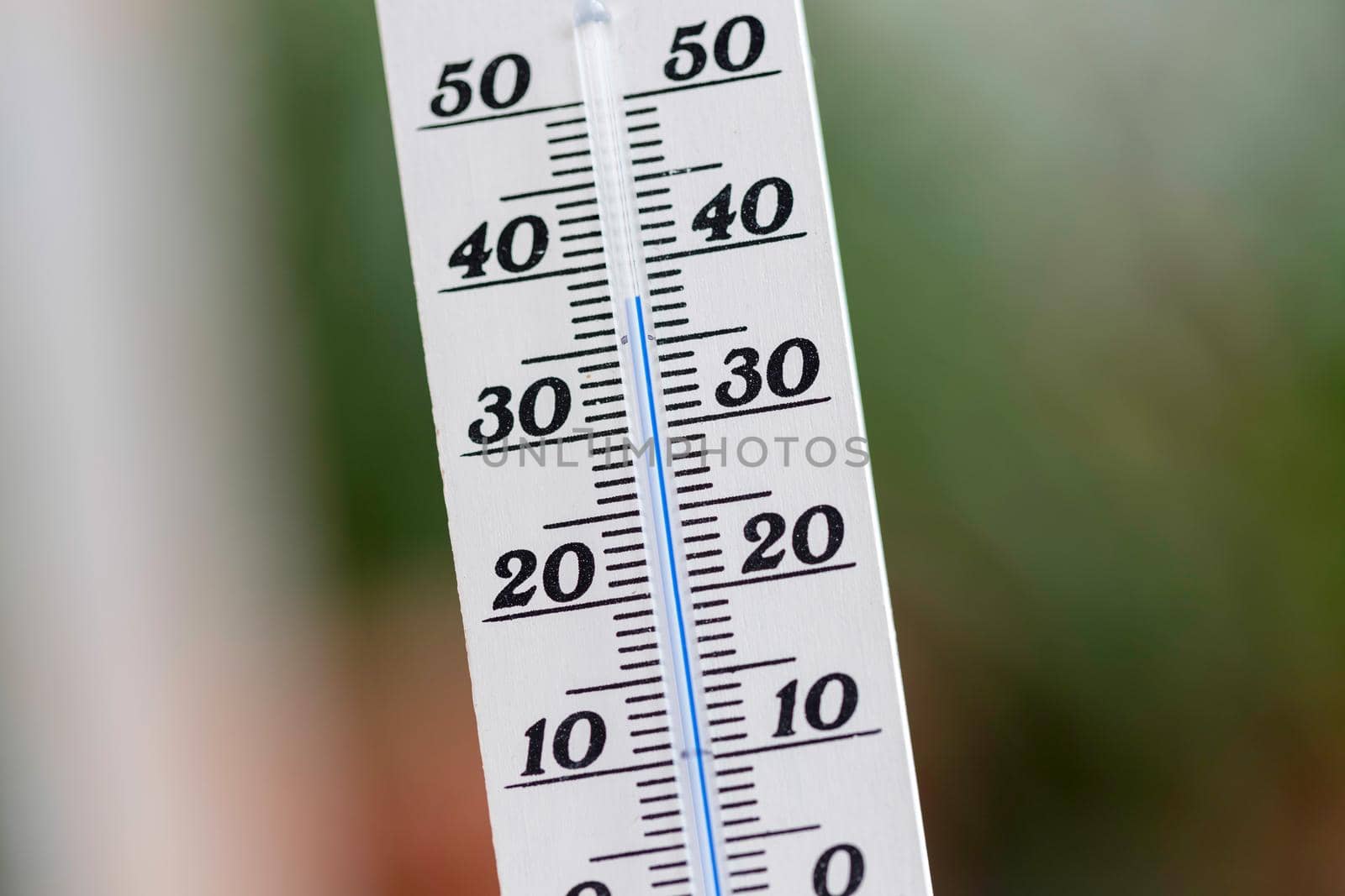 Thermometer close up picture in summer time, blurry background