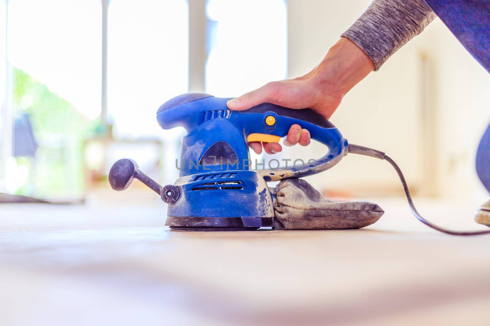 Close up of a sander power tool for DIY on wooden parquet floor