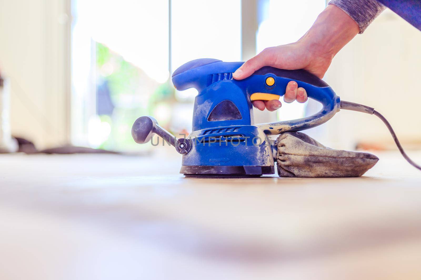 Close up of a sander power tool for DIY on wooden parquet floor