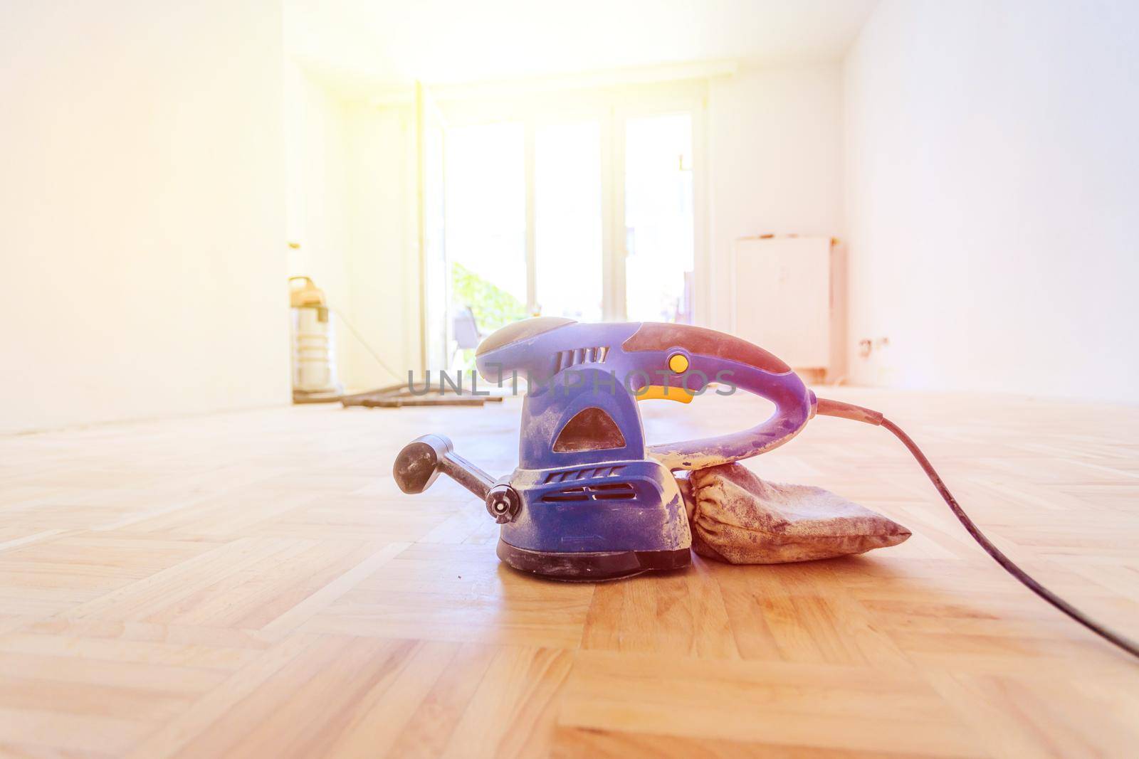Close up of a sander power tool for DIY on wooden parquet floor