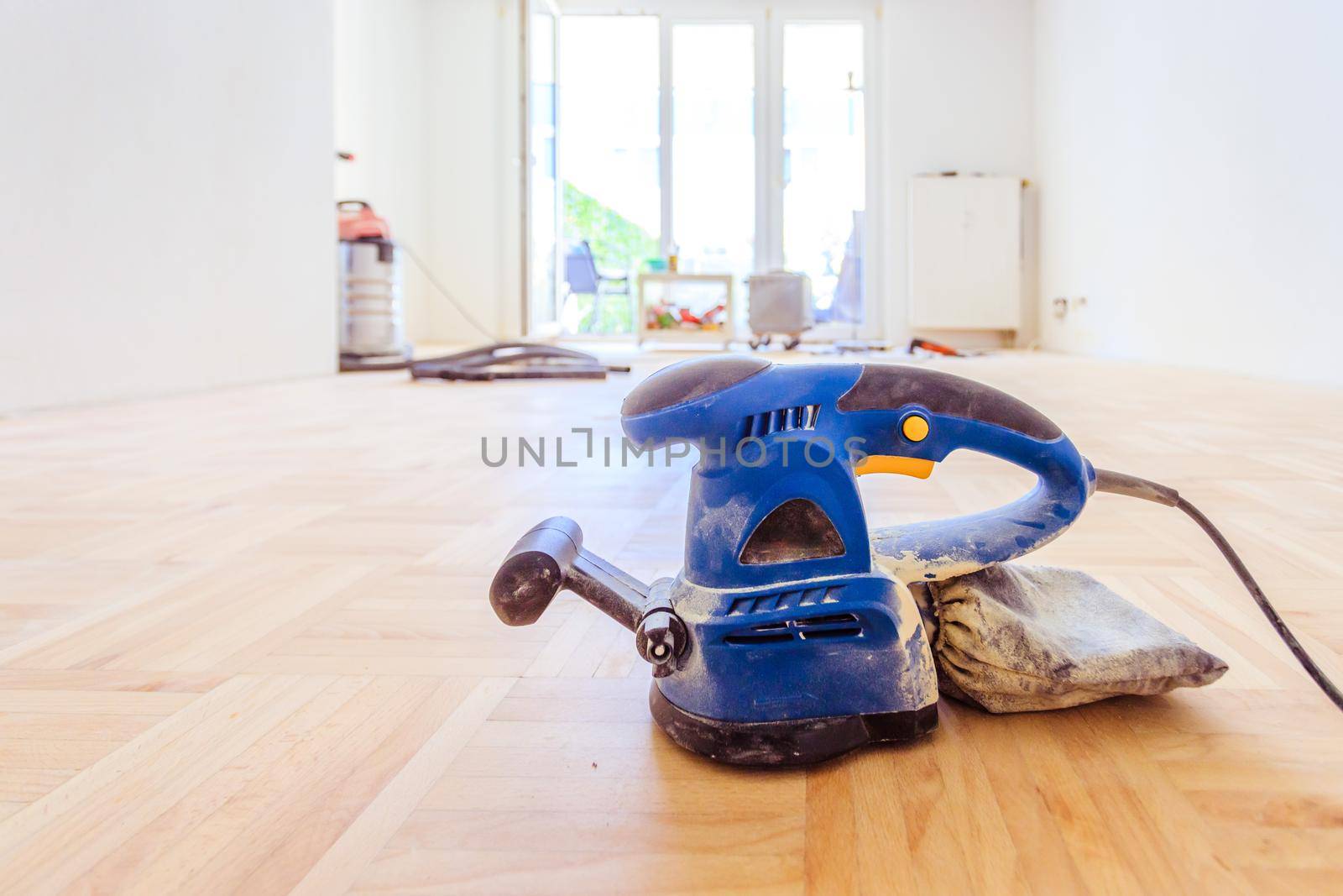 Close up of a sander power tool for DIY on wooden parquet floor