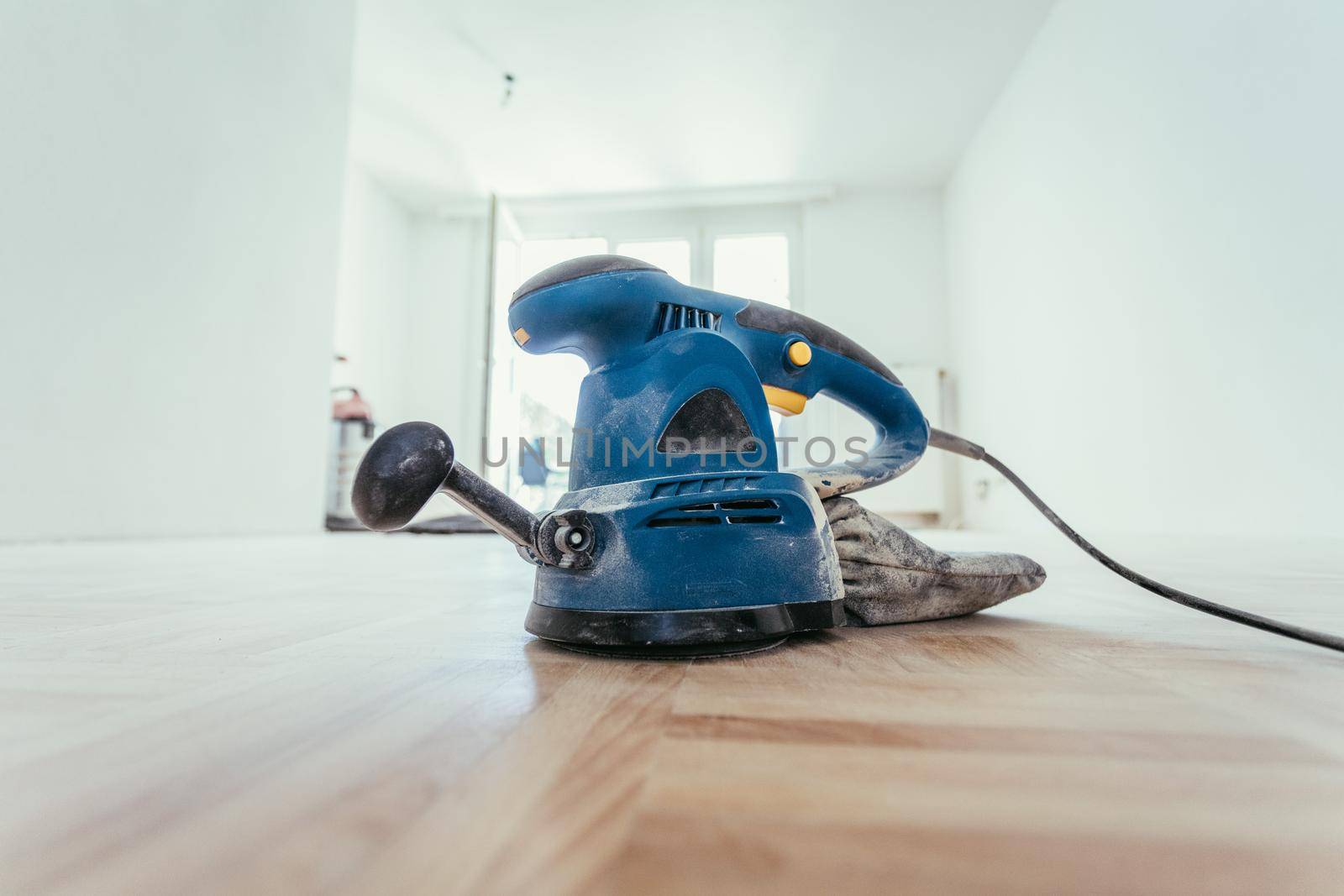 Close up of a sander power tool for DIY on wooden parquet floor