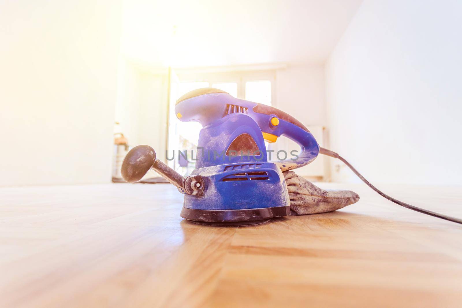 Close up of a sander power tool for DIY on wooden parquet floor
