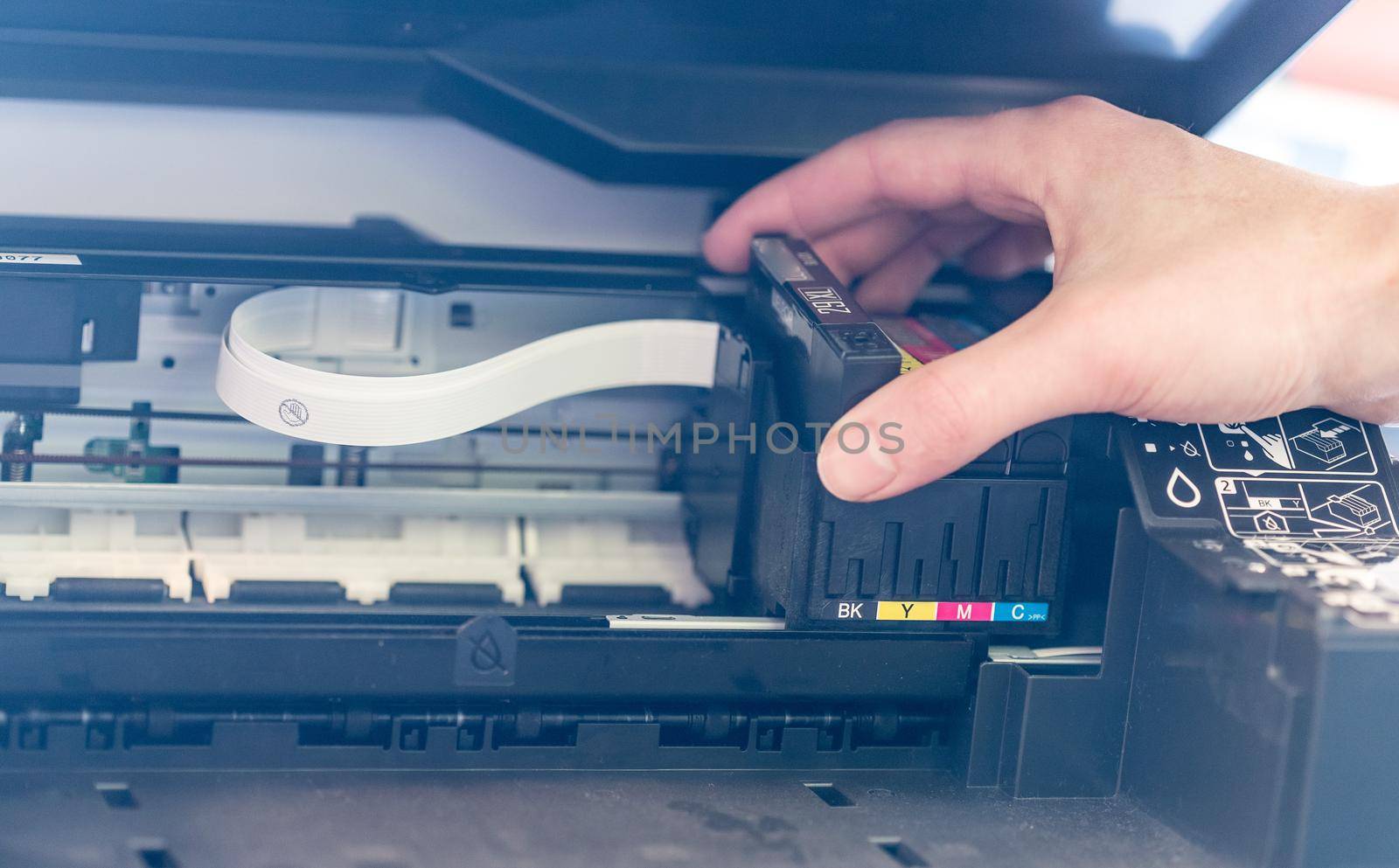 Putting new printer cartridge into the printer, inkjet.