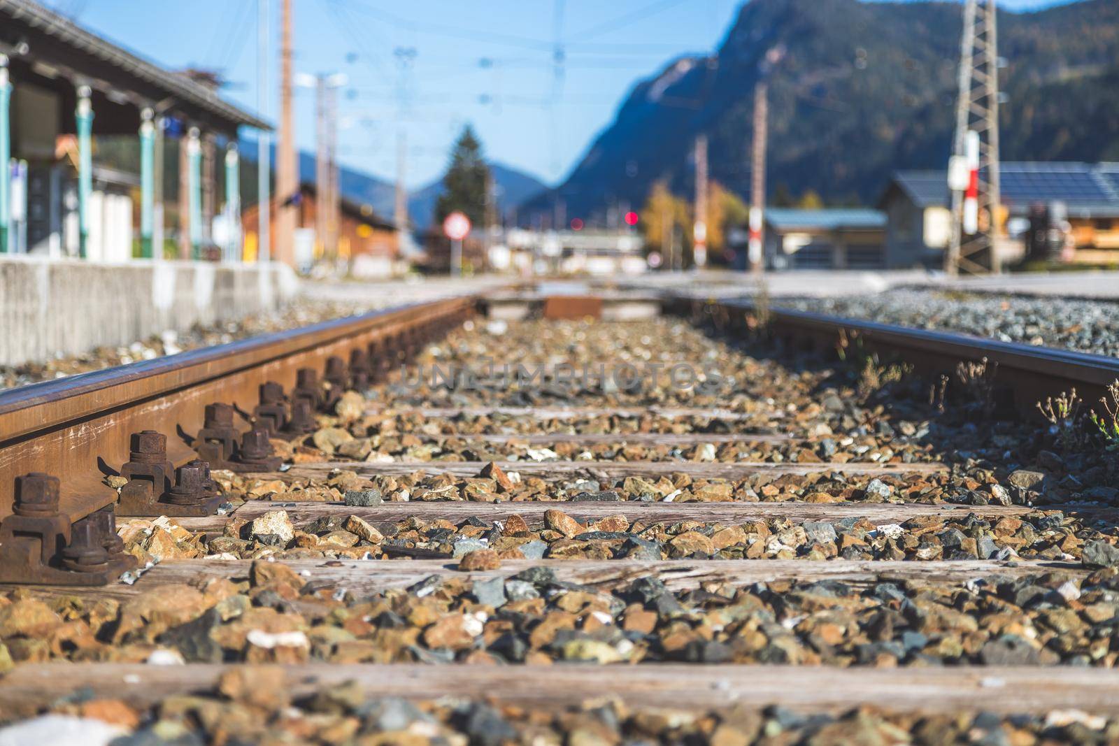 Sustainable traveling by train: Rail track and colorful, idyllic landscape in fall. by Daxenbichler