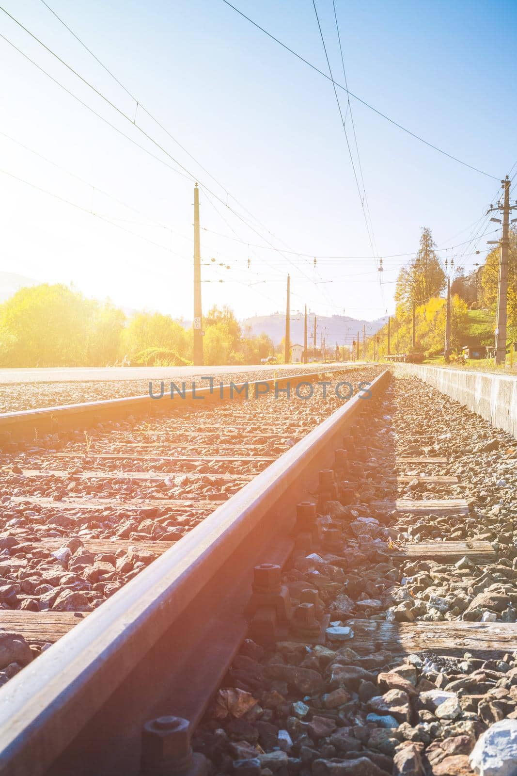 Sustainable traveling by train: Rail track and colorful, idyllic landscape in fall. by Daxenbichler