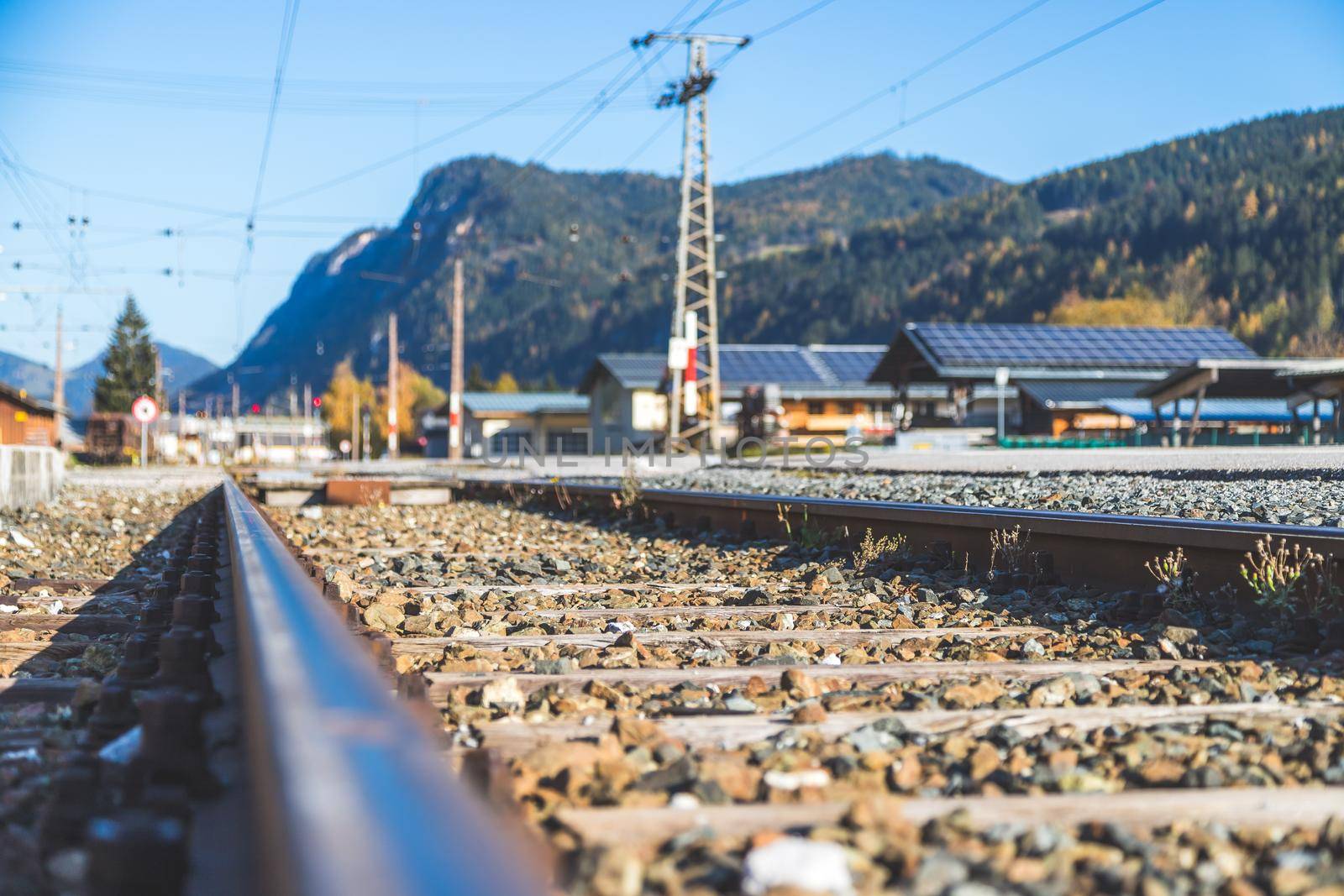 Sustainable traveling by train: Rail track and colorful, idyllic landscape in fall. by Daxenbichler