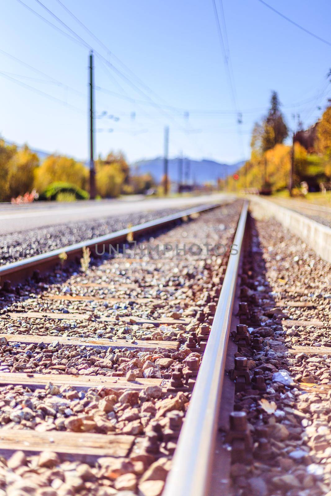 Sustainable traveling by train: Rail track and colorful, idyllic landscape in fall. by Daxenbichler