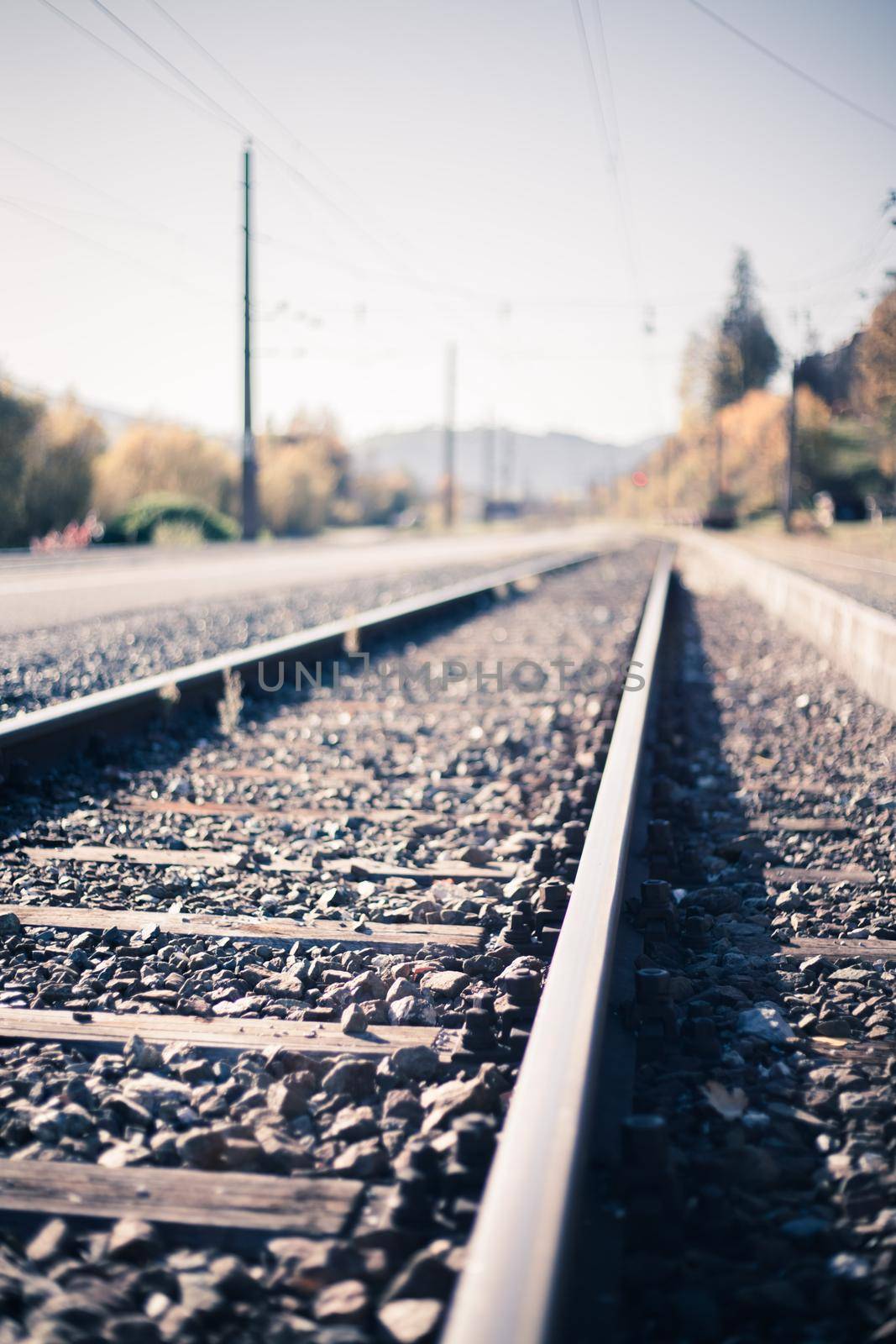 Sustainable traveling by train: Rail track and colorful, idyllic landscape in fall. by Daxenbichler