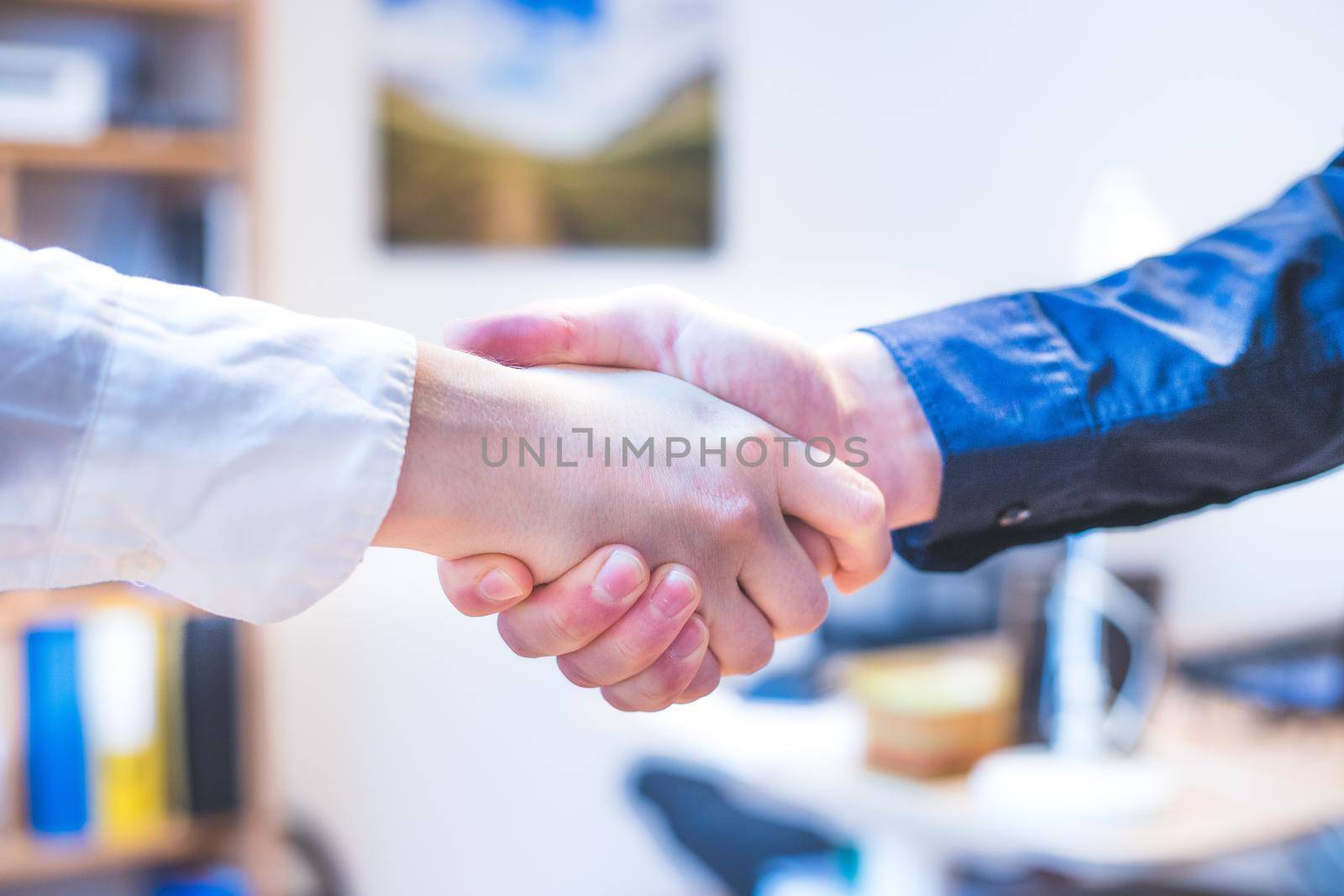 Shaking hands, concept for teamwork: Close up of man and woman shaking hands in the office by Daxenbichler