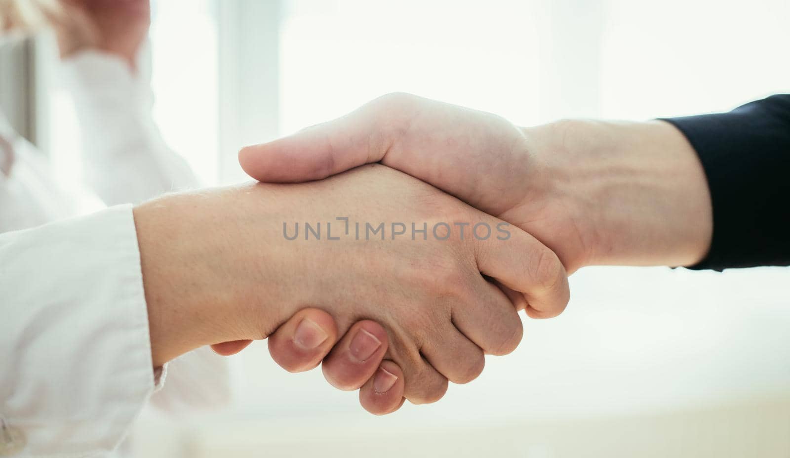 Man and woman are shaking hands, close up image, concept for human relationships
