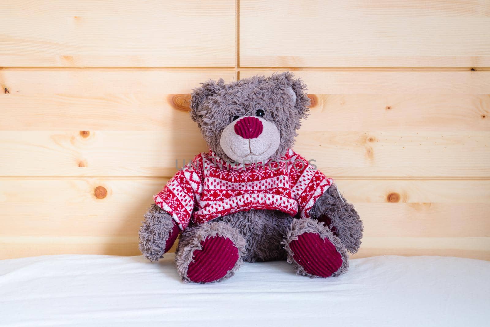 Cute teddy bear toy is sitting in the bed, wakeup at morning