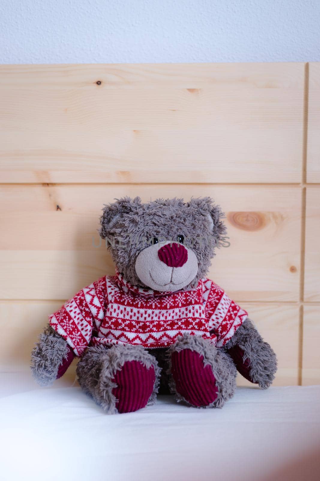 Cute teddy bear toy is sitting in the bed, wakeup at morning